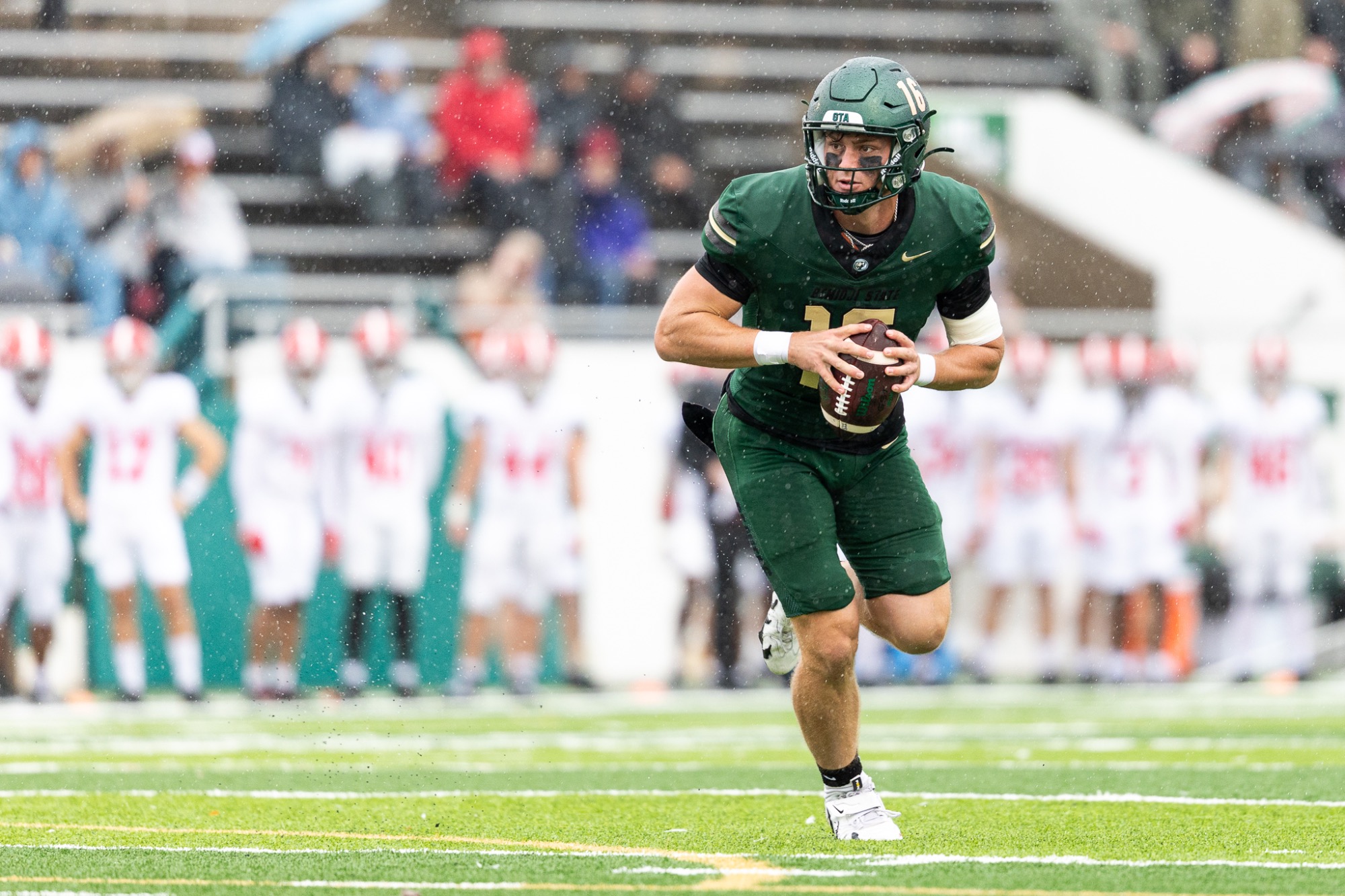 Mack Molander runs with the football in open field during a rainy game against Minot State University.