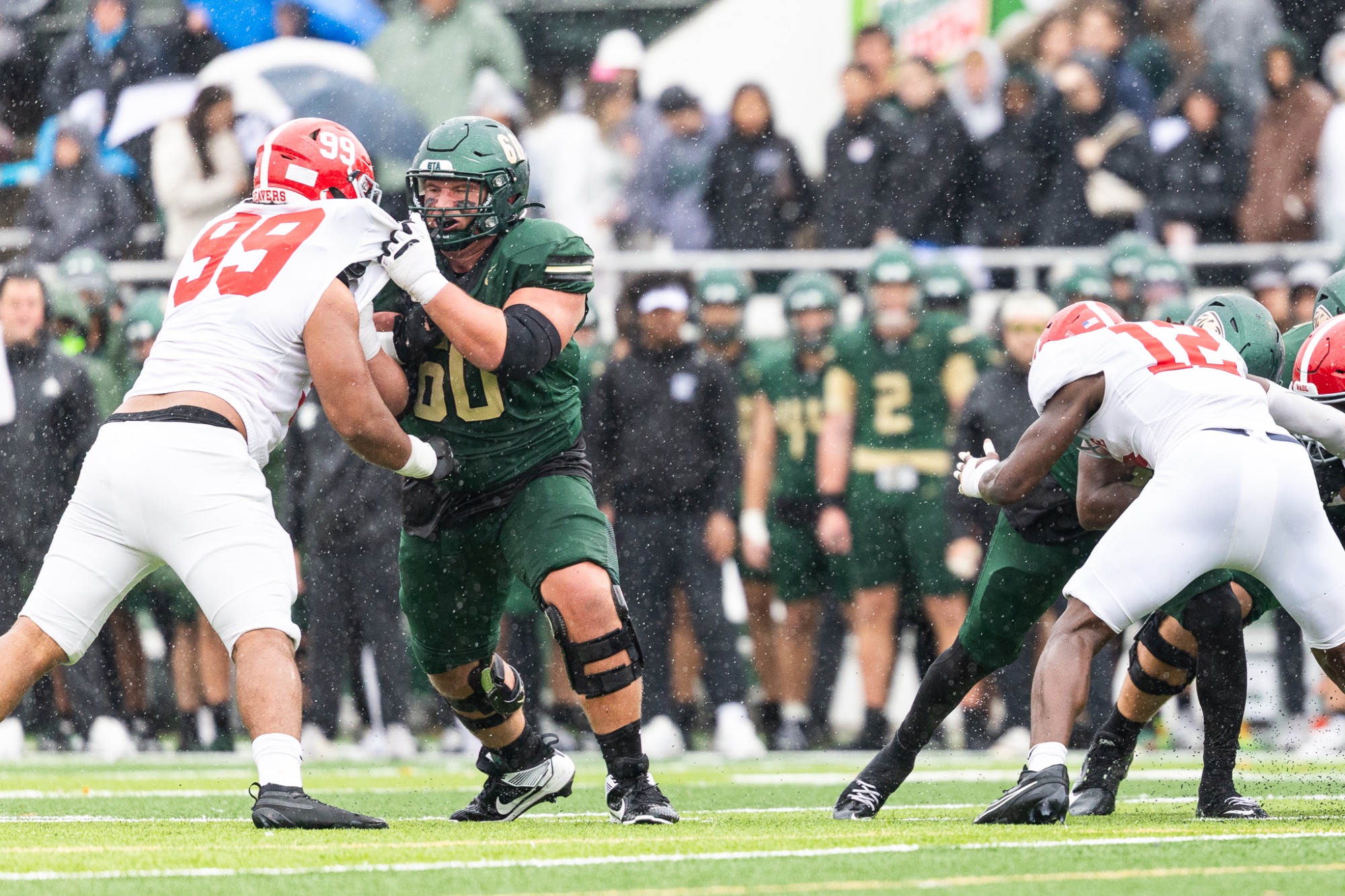 Zach Ott blocks Minot State's during a rushing play in rainy conditions.