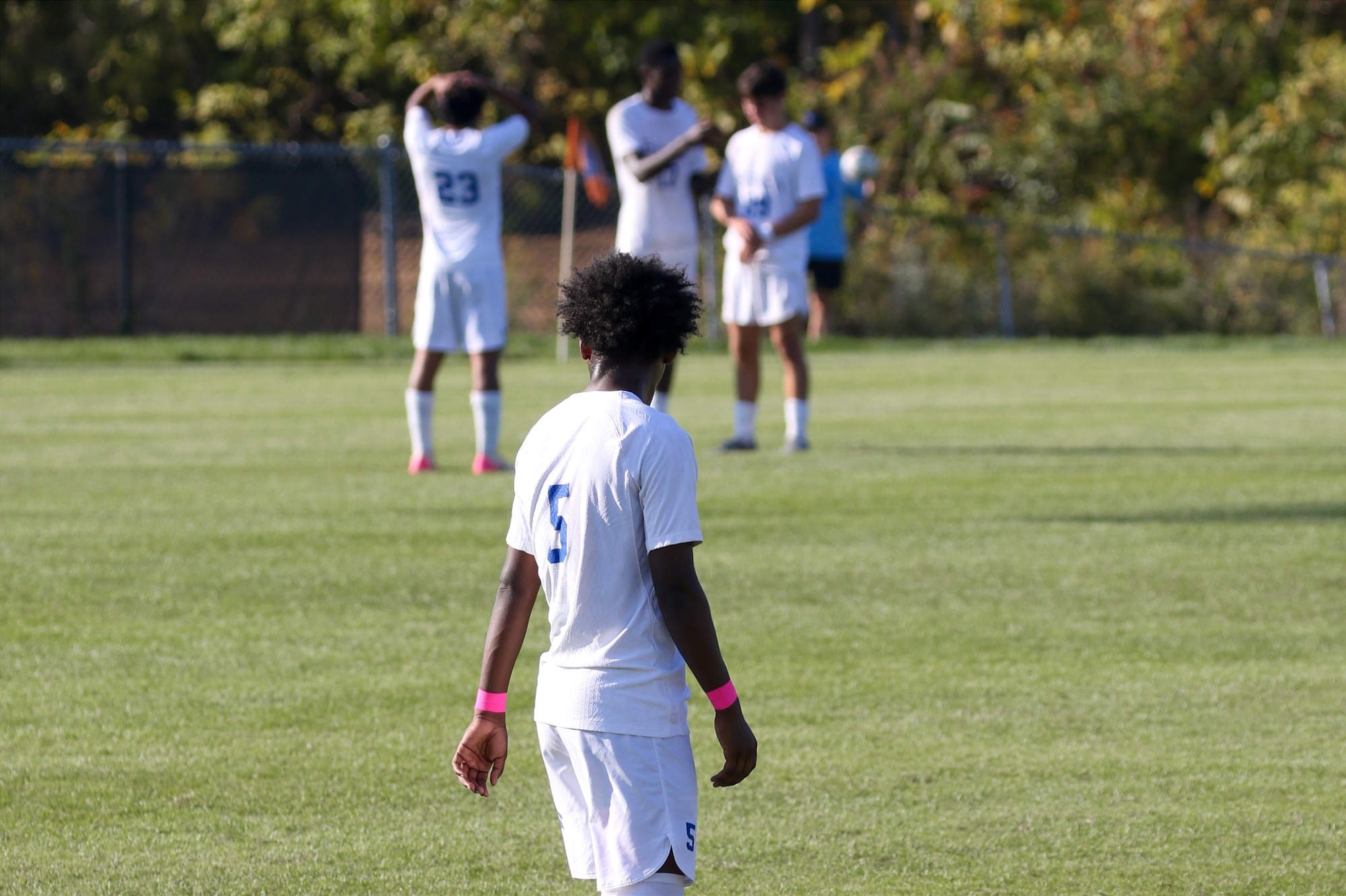 Ali walks on field looking at teamates