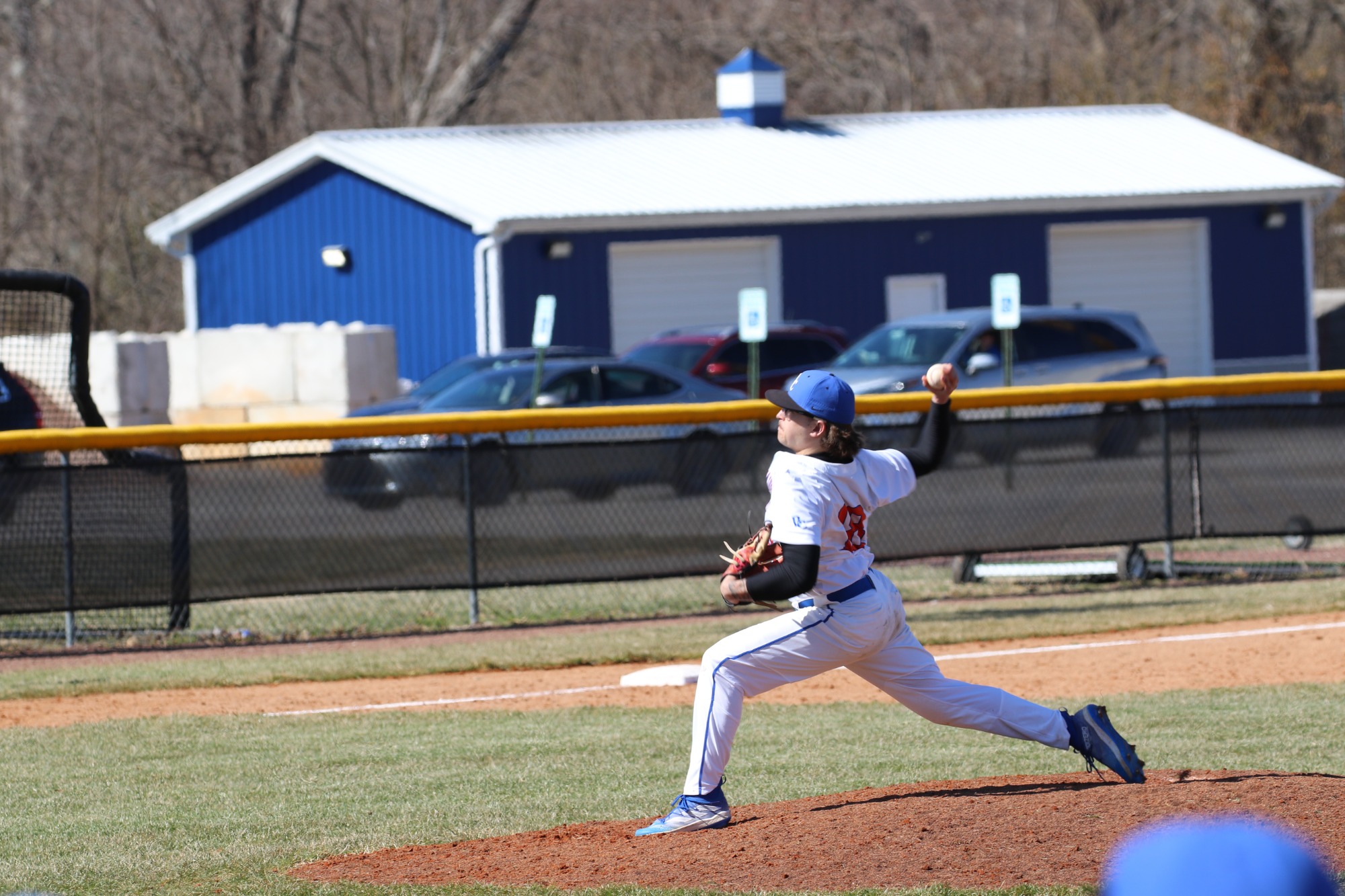 #18 – Seth Galloway – finishing his pitching motion after delivering the ball.