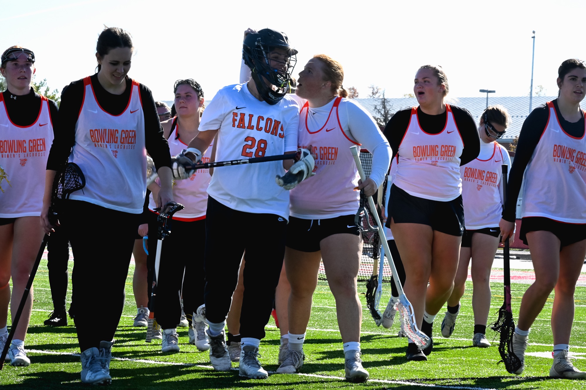 BGSU women's lacrosse cheers their goalie.