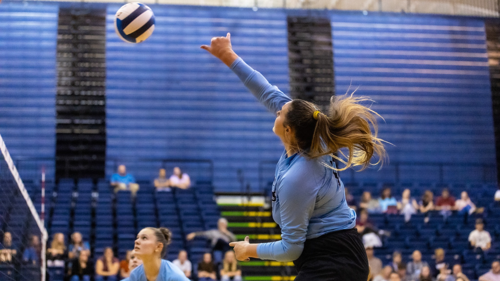 Volleyball player hitting the ball over the net