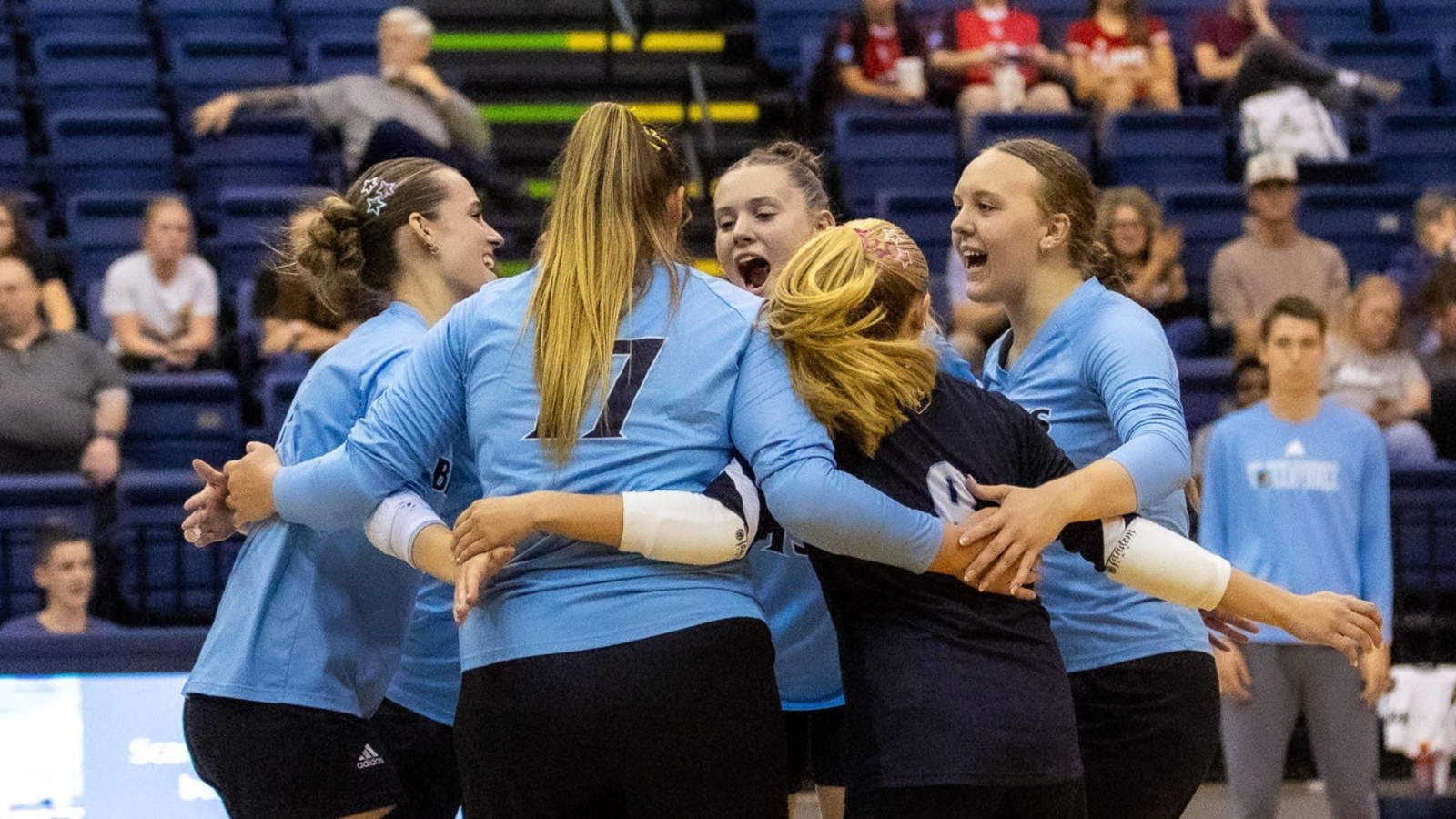 Volleyball team smiling together in a huddle