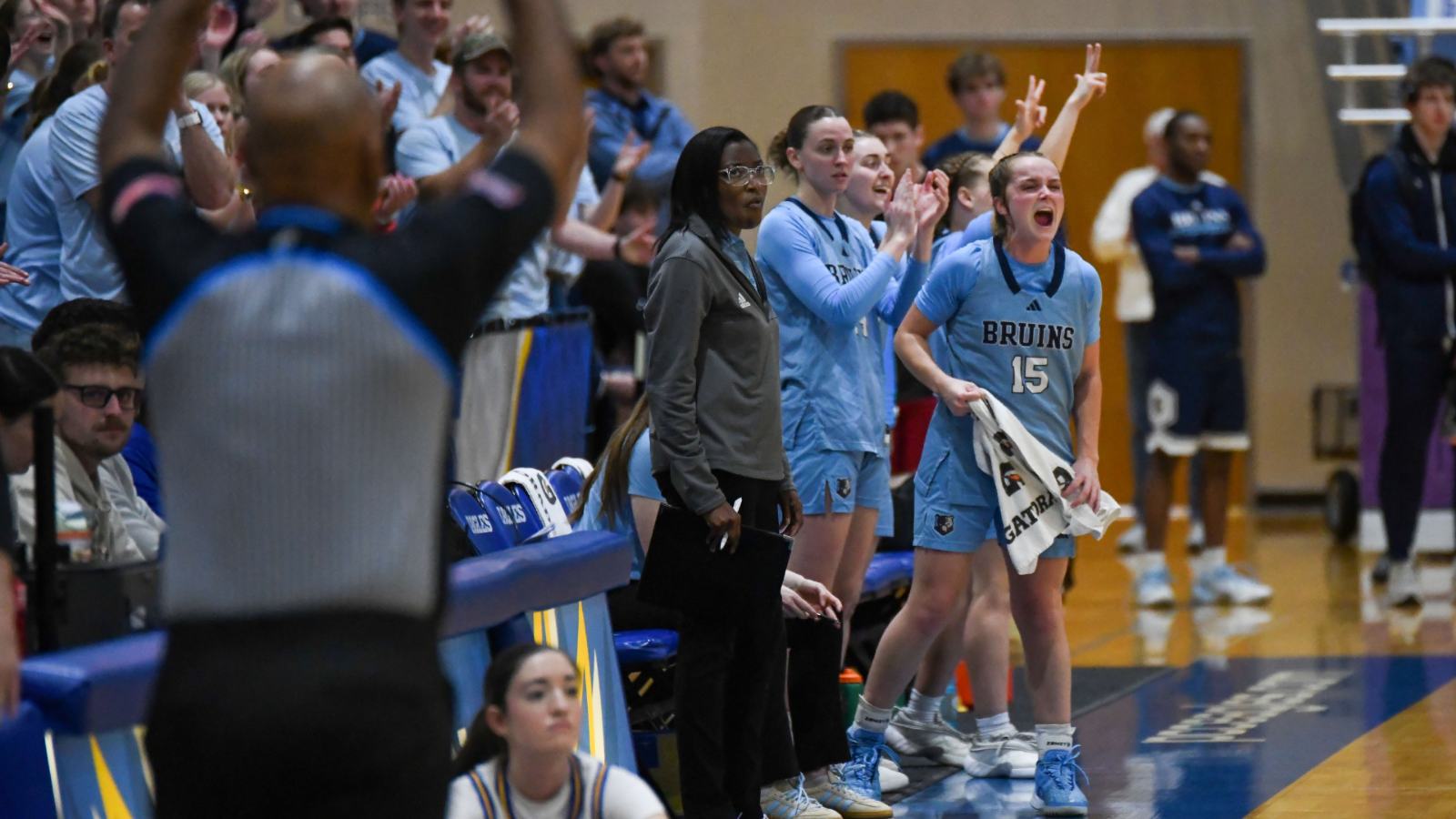 women's basketball players cheering on the sideline