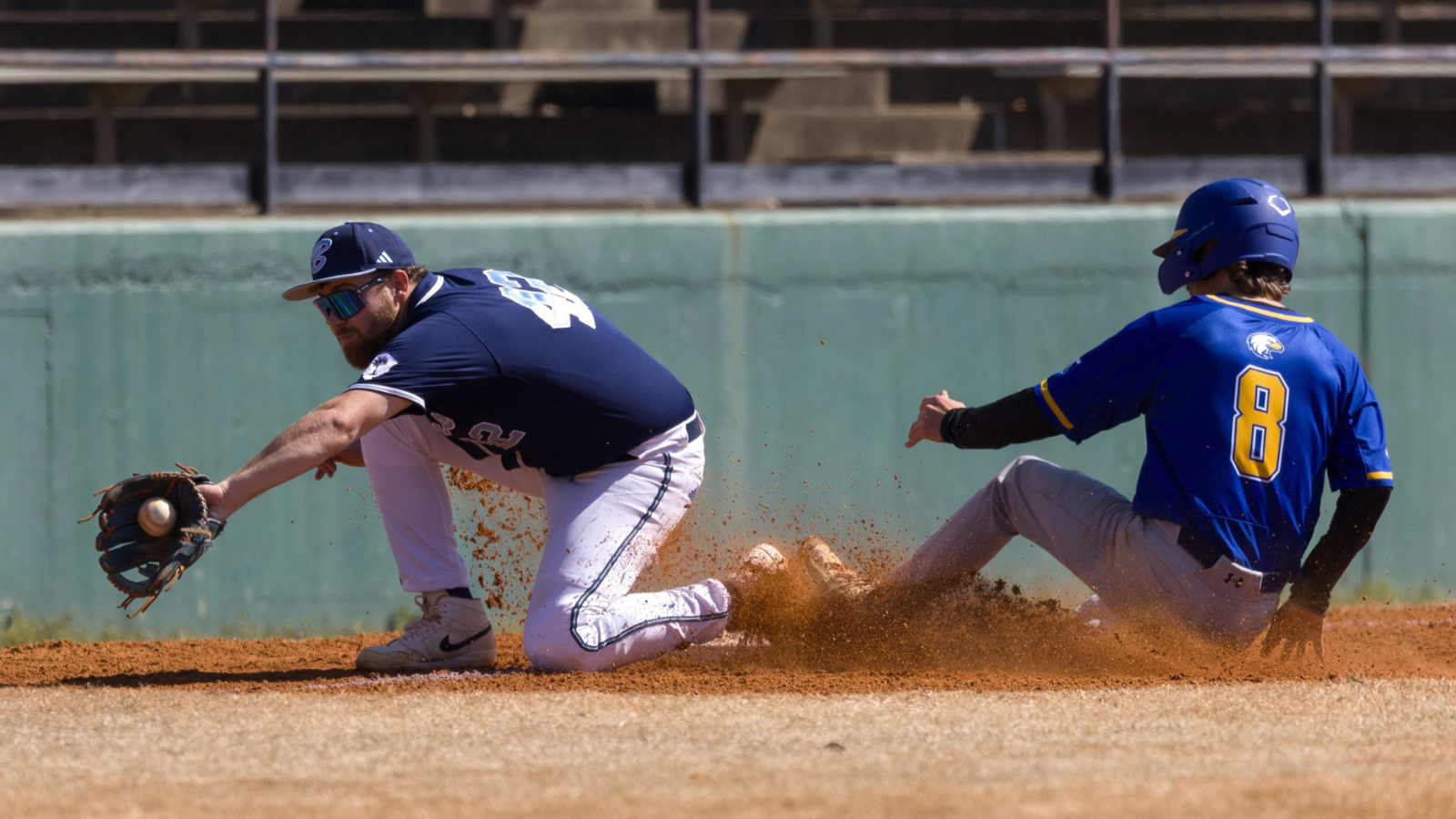 third baseman baseball player catches the ball with runner on base