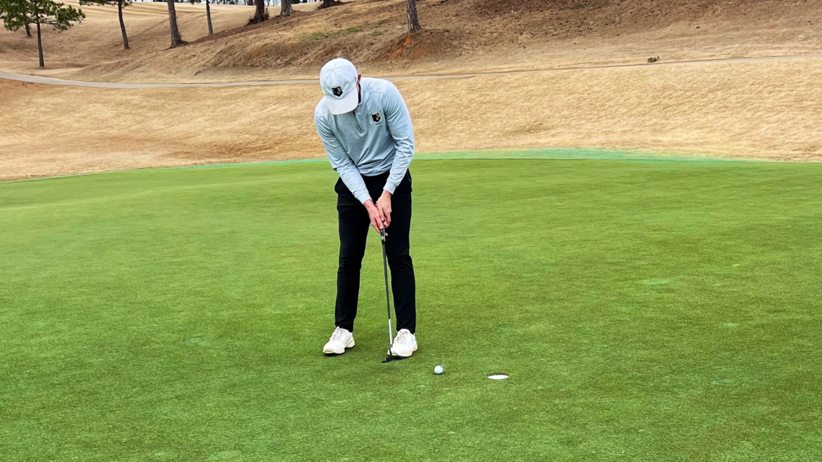 Bruins Golfer putts ball