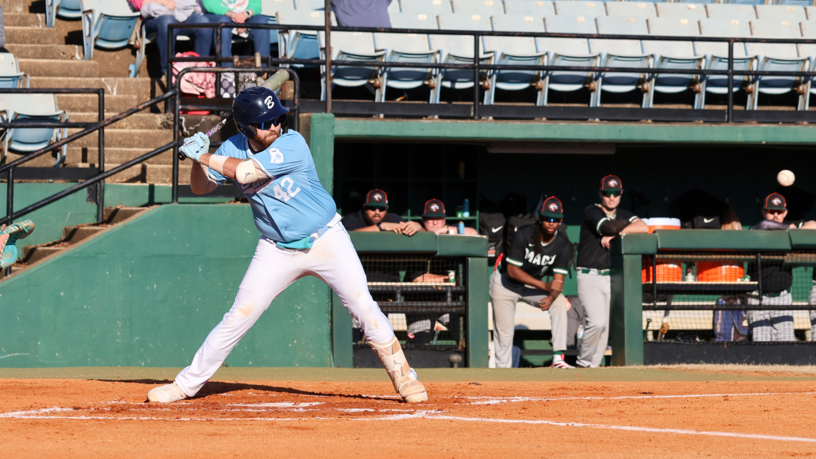 Bruins baseball player swings bat at baseball