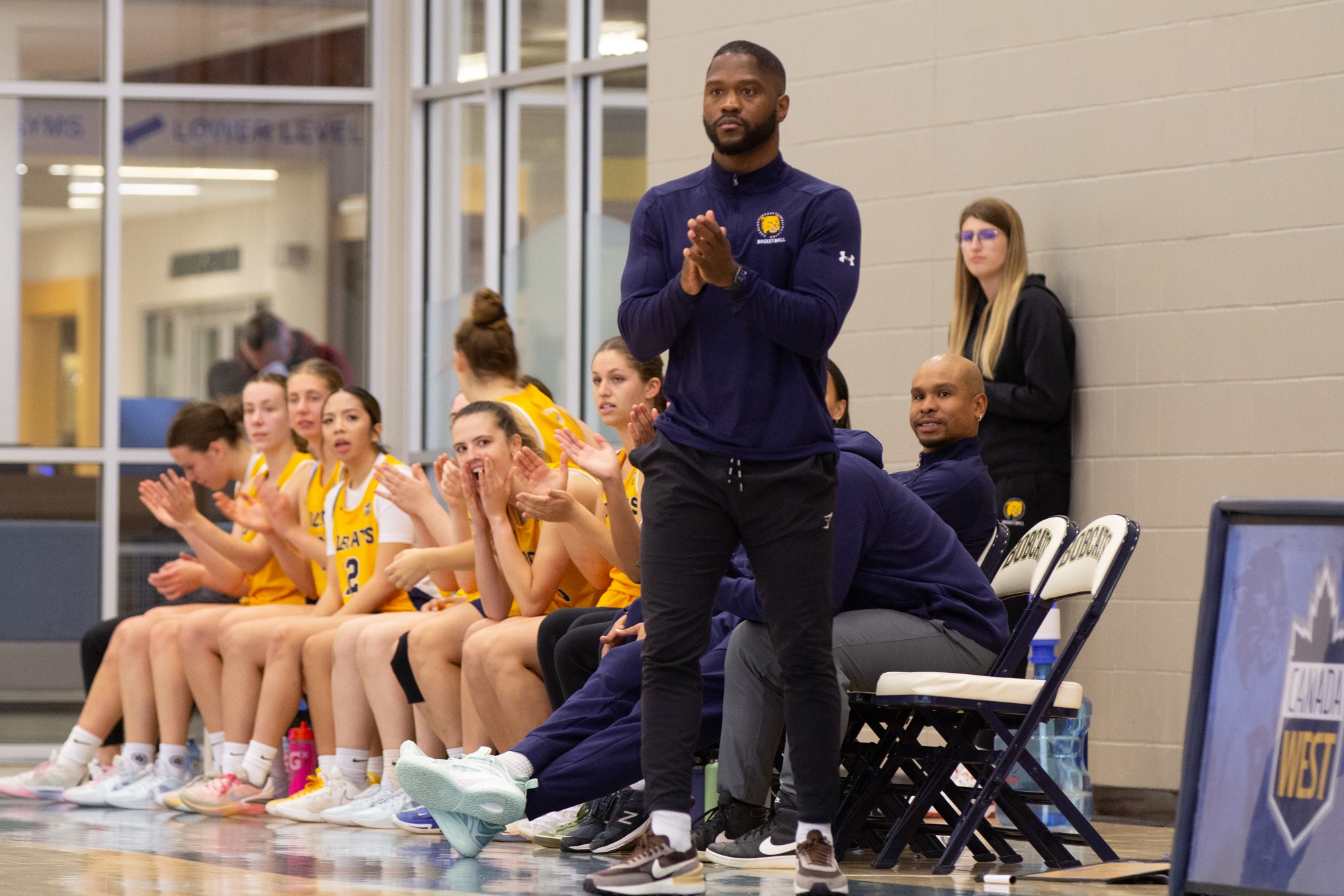 Women's Basketball bench looks on during a pre-season game