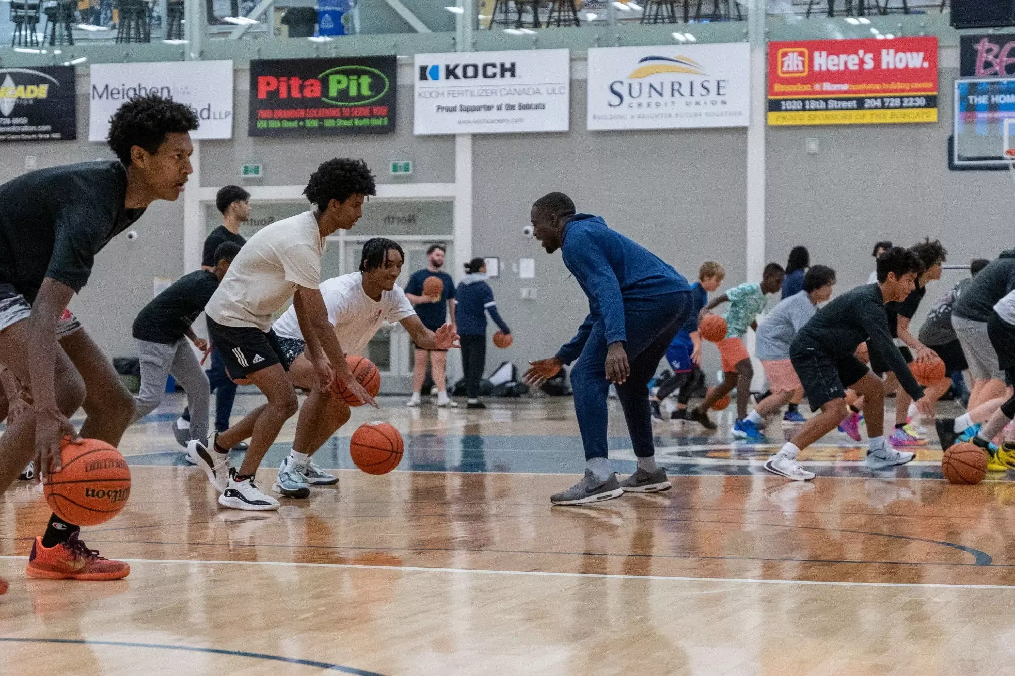 Basketball Camp participants are run through a drill by Silas Owusu-Acheaw of the Bobcats