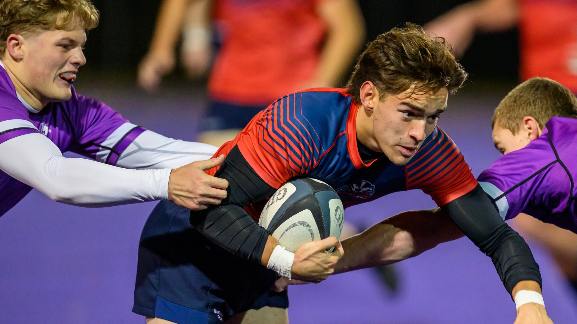 Brady Perkins running with the ball against Western defenders