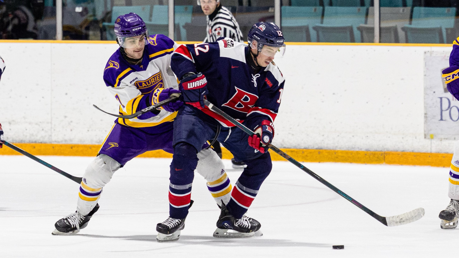 A Brock men's hockey player battles for possession of the puck