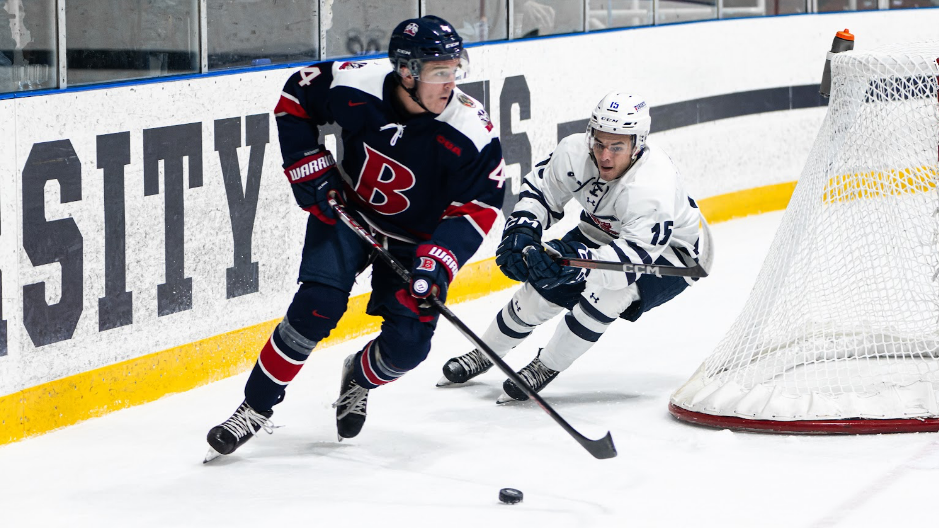 A Brock men's hockey player stakes around the net, protecting the puck 