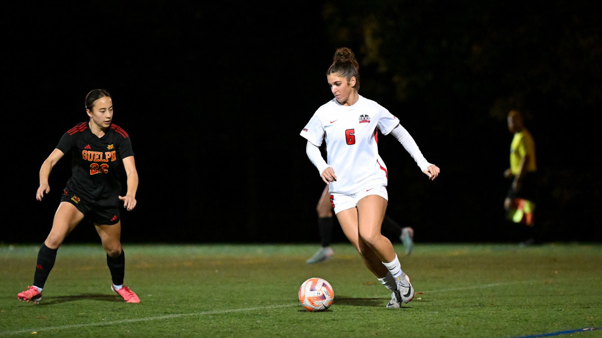 A Brock women's soccer player dribbles the ball forward