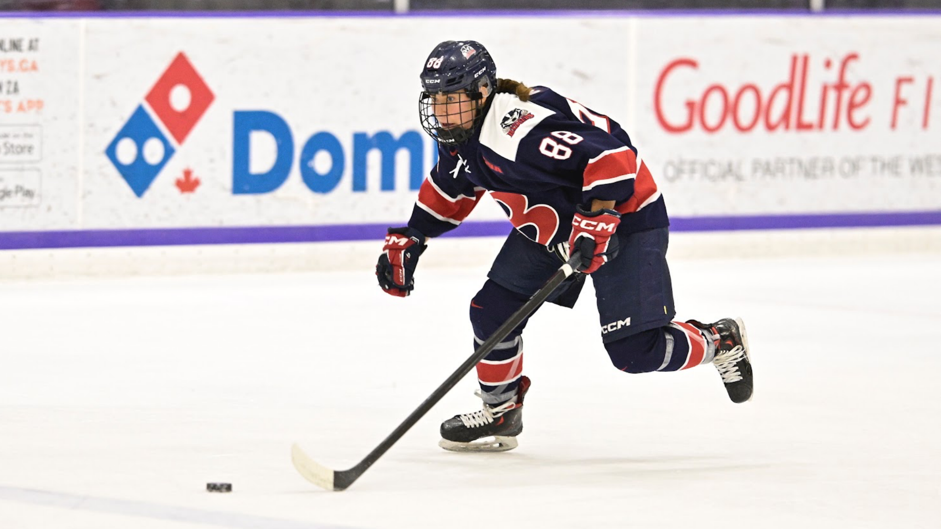A Brock women's hockey player stakes forward with the puck