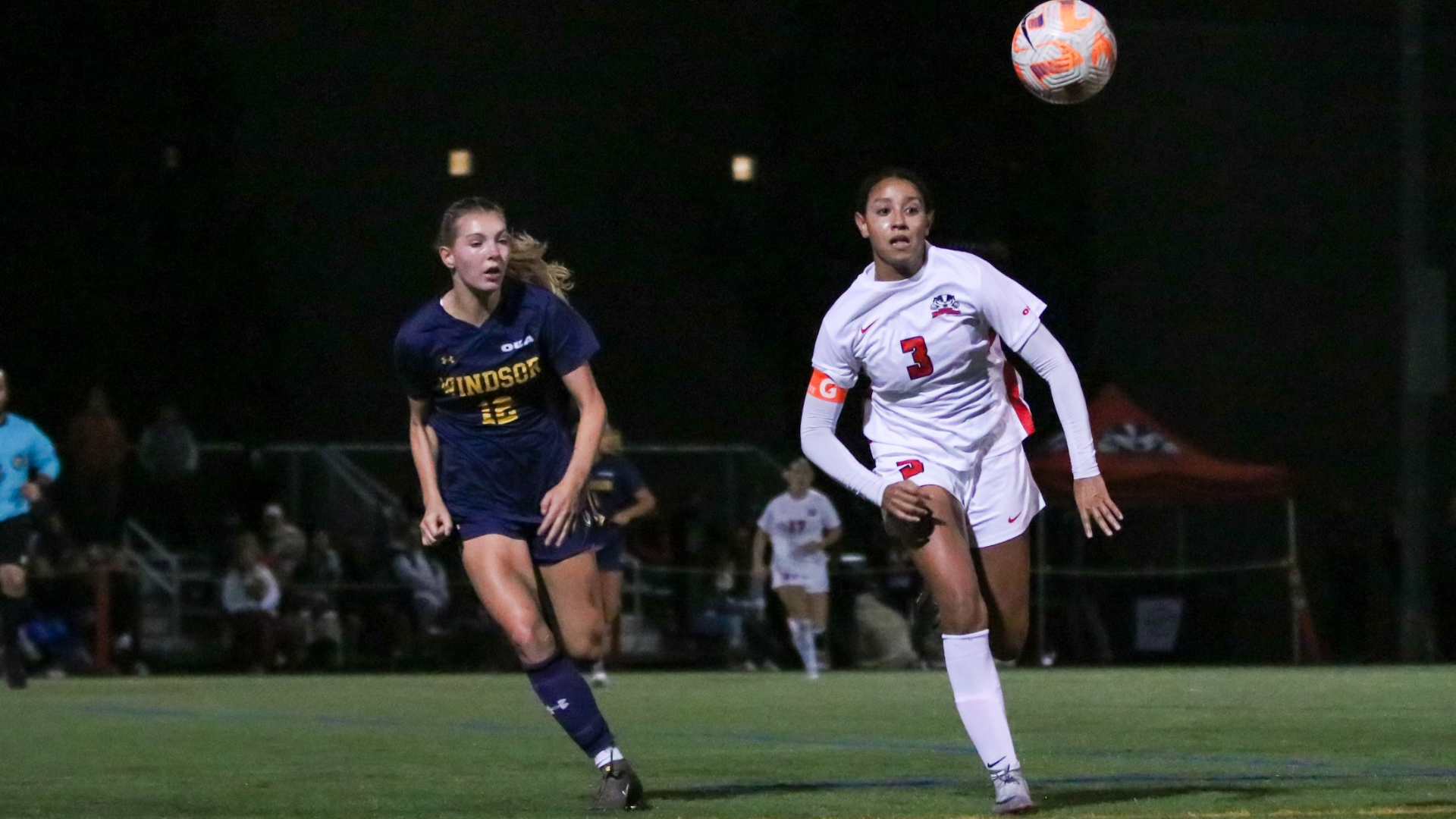 A Brock women's soccer player races to win a bouncing ball