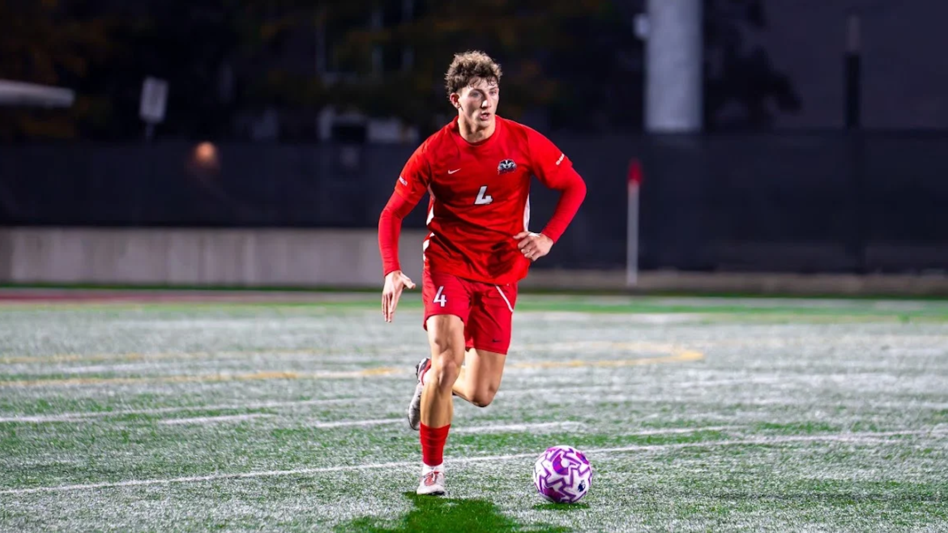 A Brock men's soccer player dribbles the ball forward