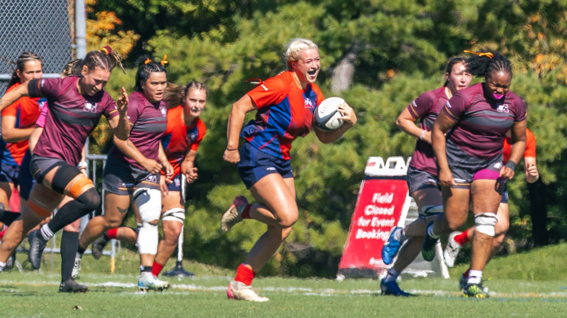 A Brock women's rugby player runs past her opposition