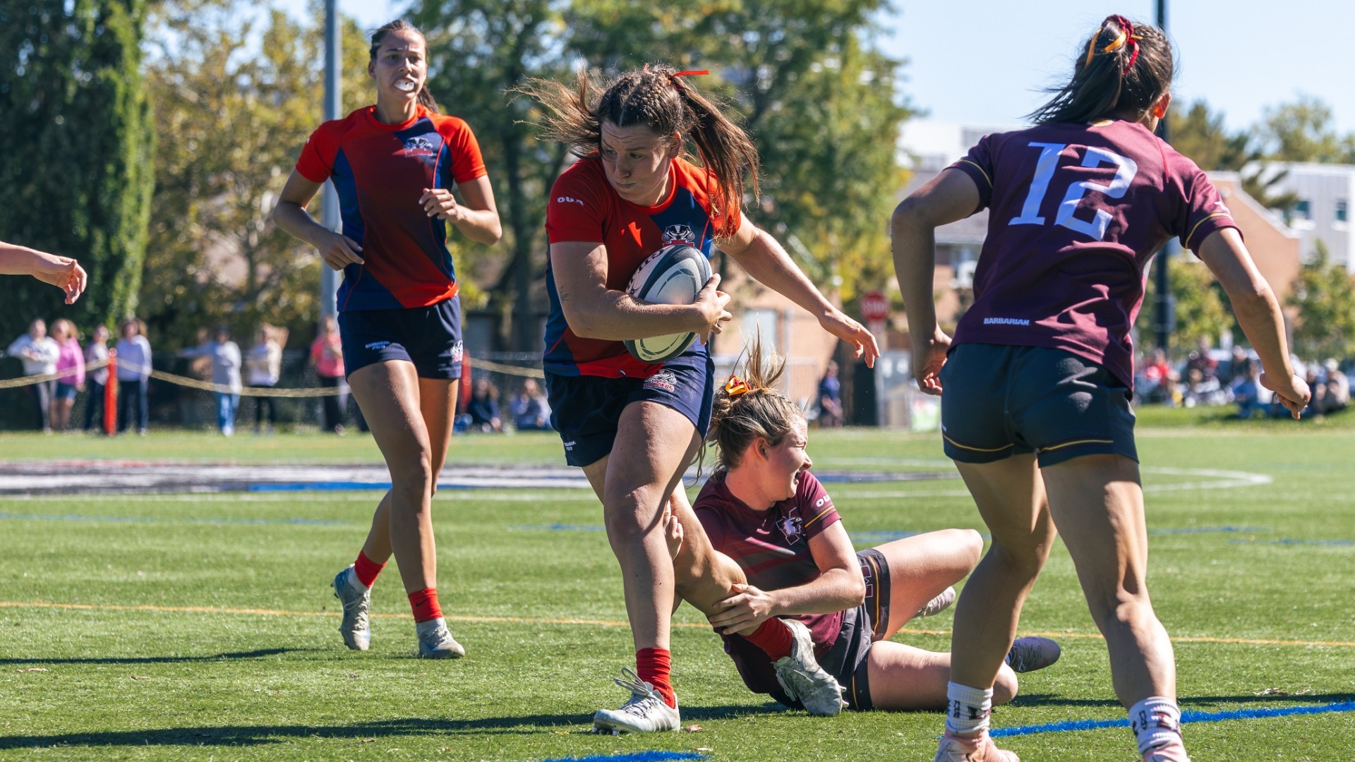A Brock women's rugby player breaks a tackle