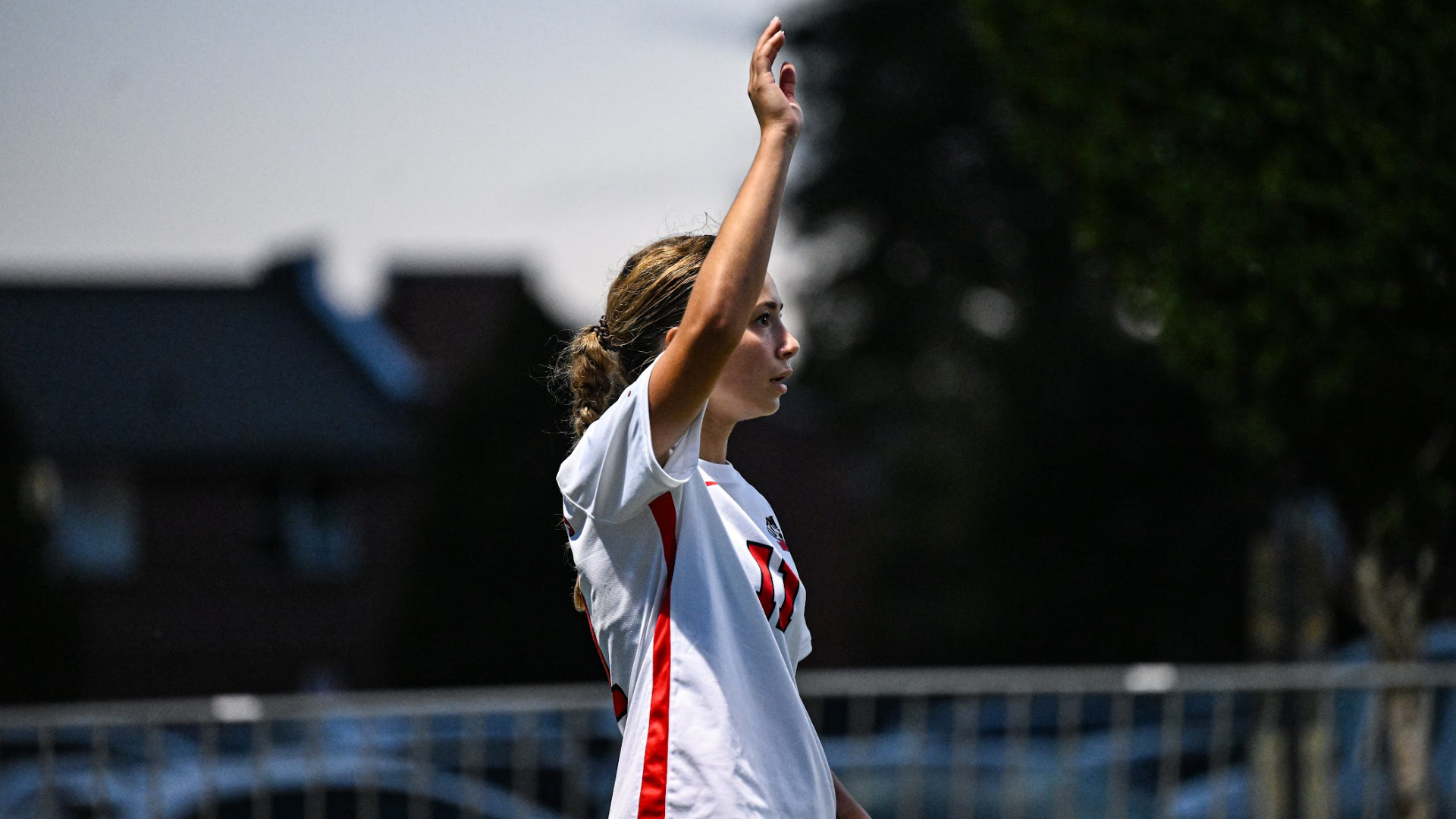 A Brock women's soccer play raises her hand