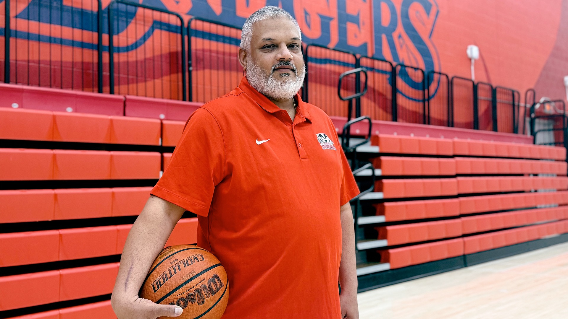 Ajay Sharma in Bob Davis Gym holding a basketball