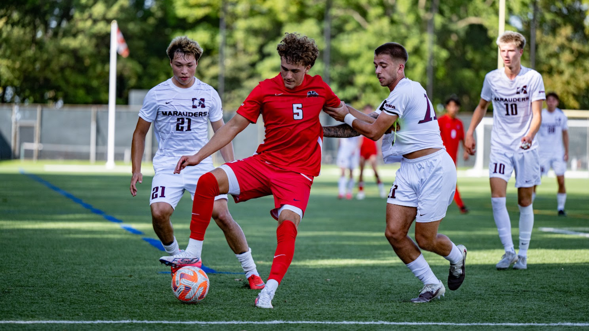 A Brock Badgers men's soccer player protects the ball from the opposition