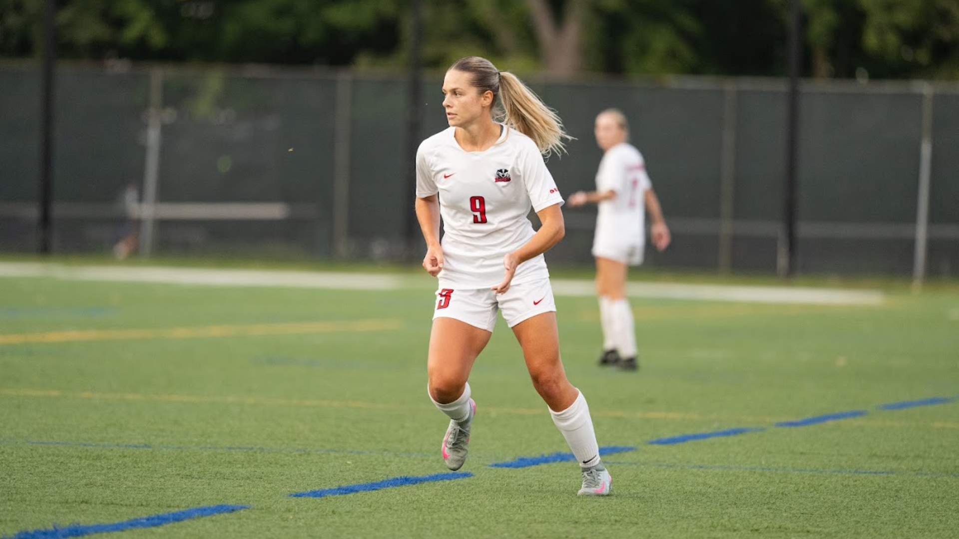 A Brock women's soccer player strides forward