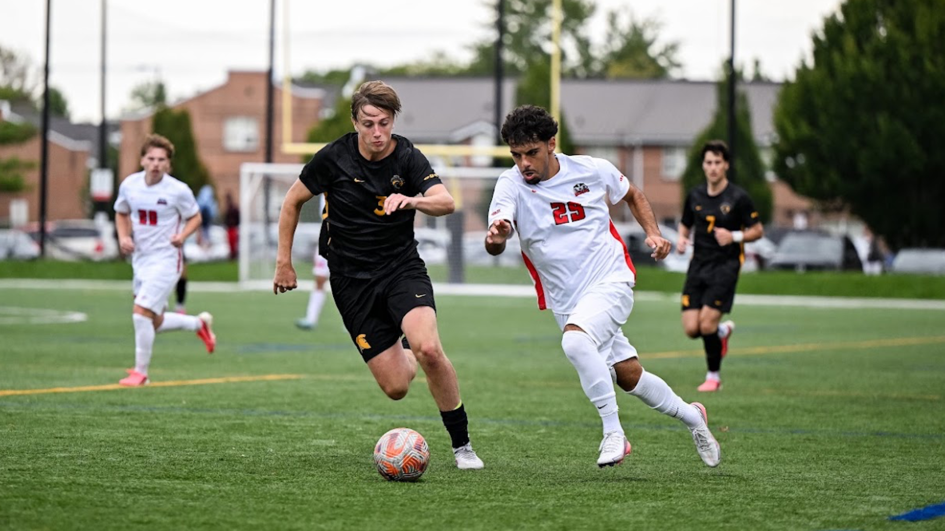 A Brock men's soccer player holds off the opposition