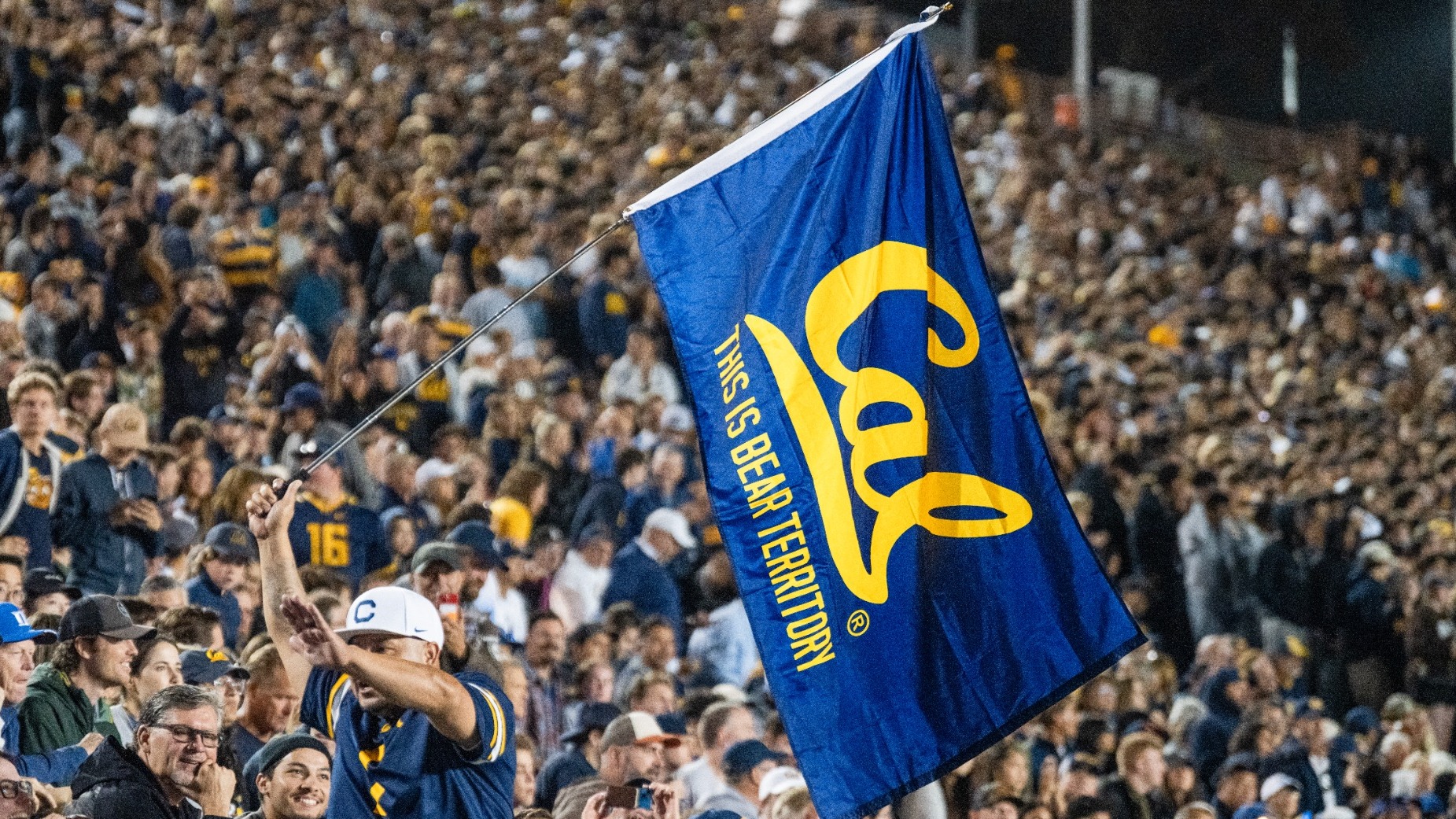 Cal fan waves flag and gives high fives to fans. October 4, 2025; Berkeley, California, USA; California Golden Bears vs Duke Blue Devils at California Memorial Stadium. Mandatory Credit: Kahlil Gray / KLC Fotos