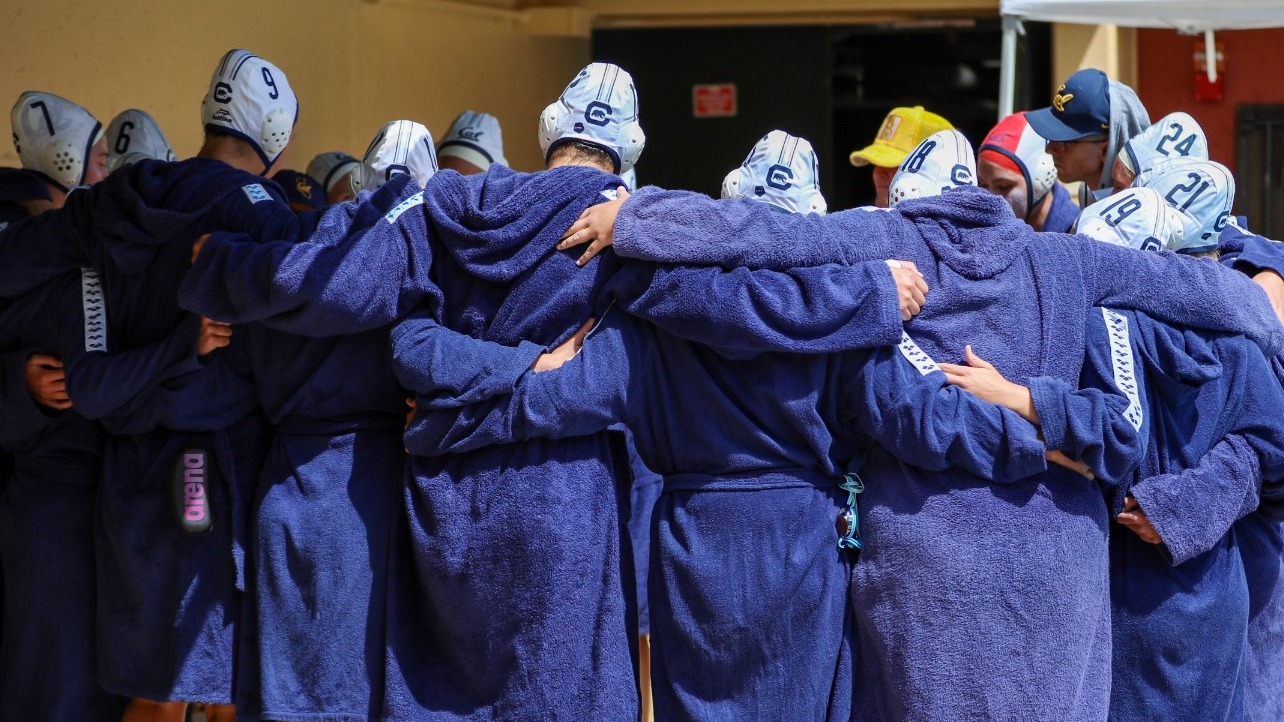 Cal players and staff huddle up before a game at Stanford