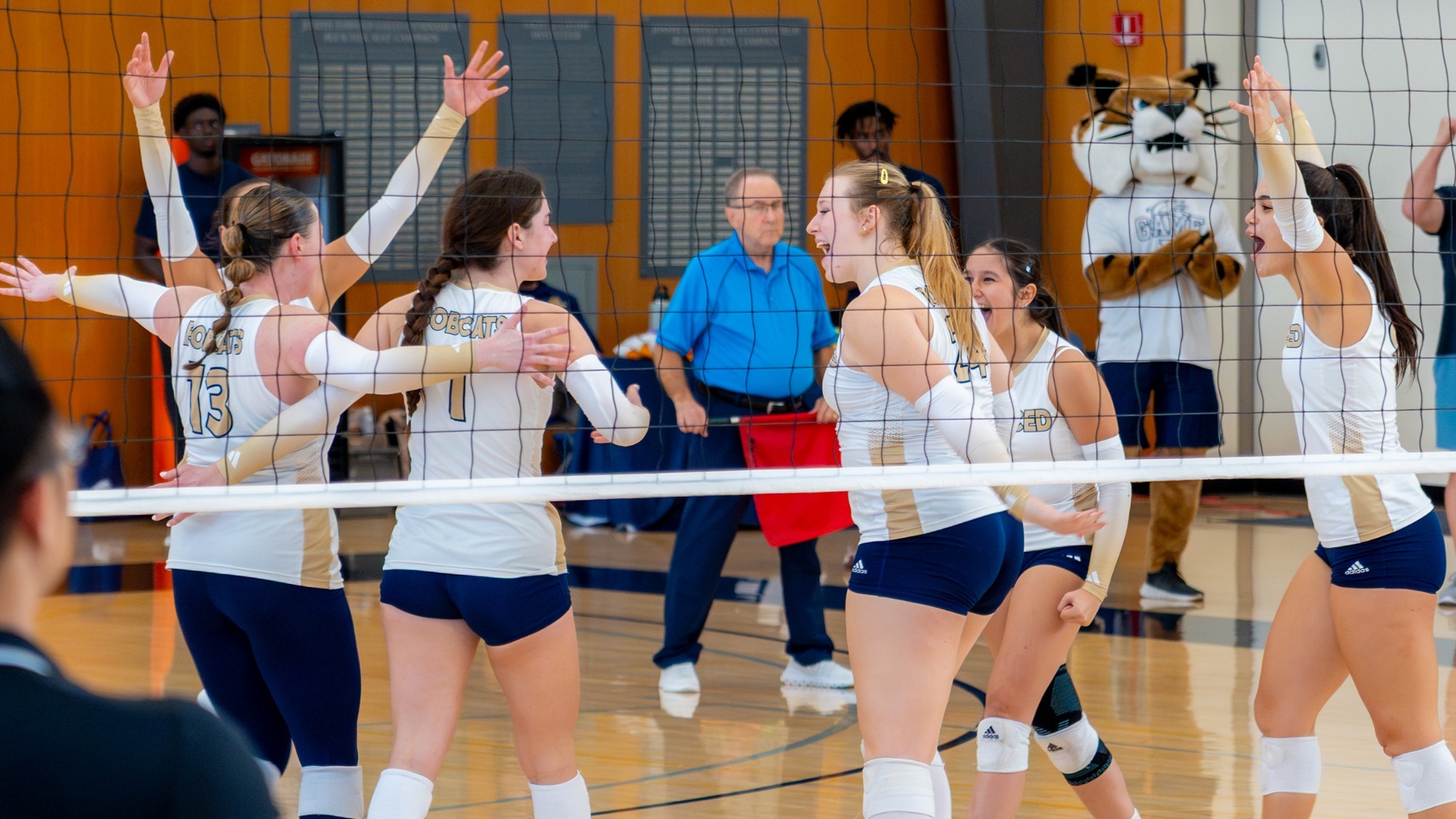UC Merced Women's Volleyball celebrate a point on Hostetler Court. Morgan Wilson and Kyra Miller are in the center of the action.