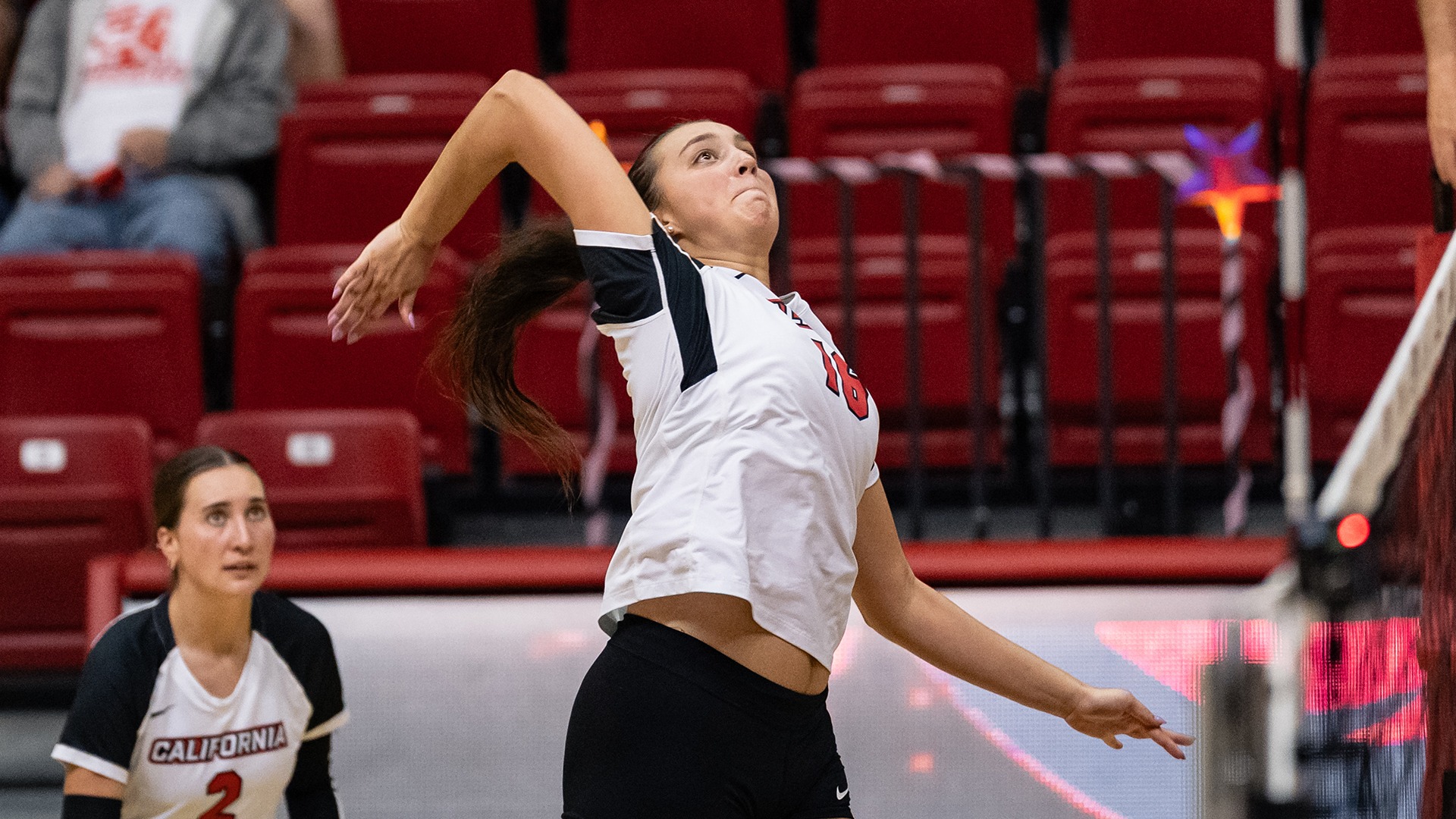 California volleyball player Riley Evans leaps and cocks her arm back to spike the ball near the net.