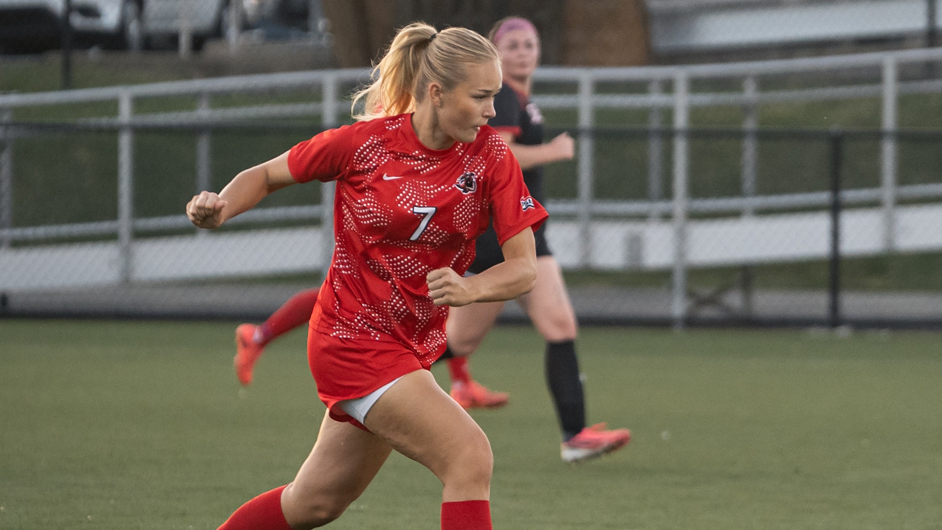 Hedda Bjoerkman sprints down the field in a red uniform during a California soccer game.