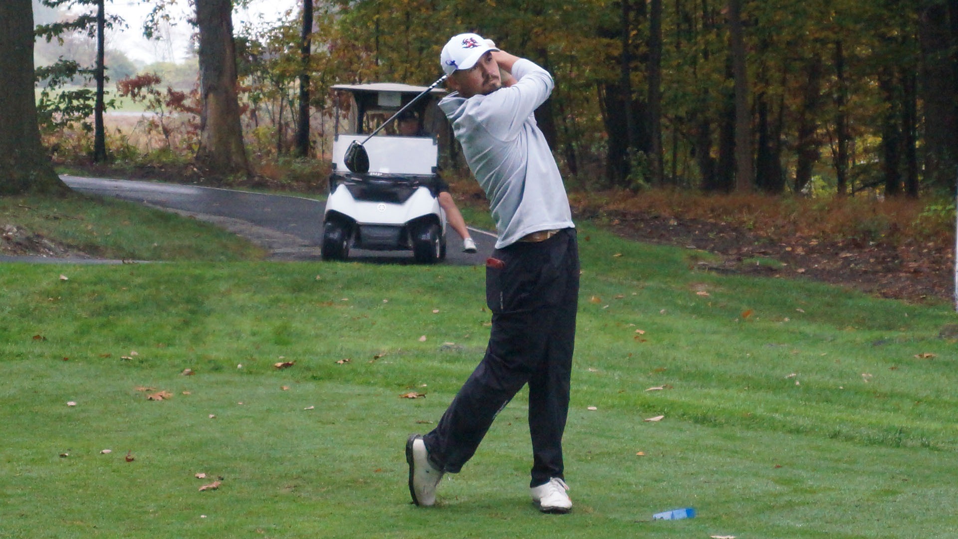 Nixen Erdely finishing a golf swing on the tee during a tournament.