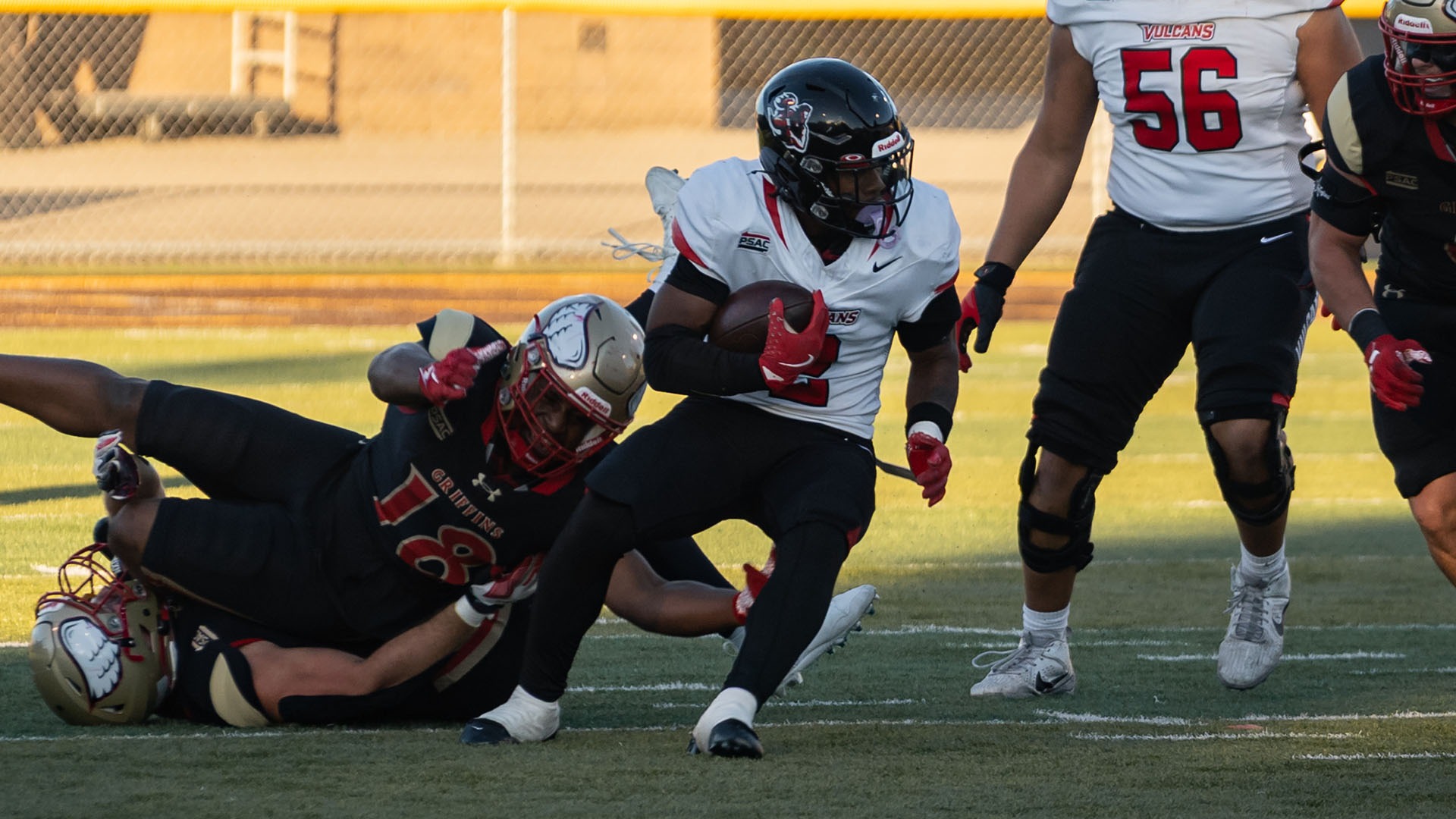California running back Bobbie Boyd Jr. carries the football past defenders attempting a tackle during a game.