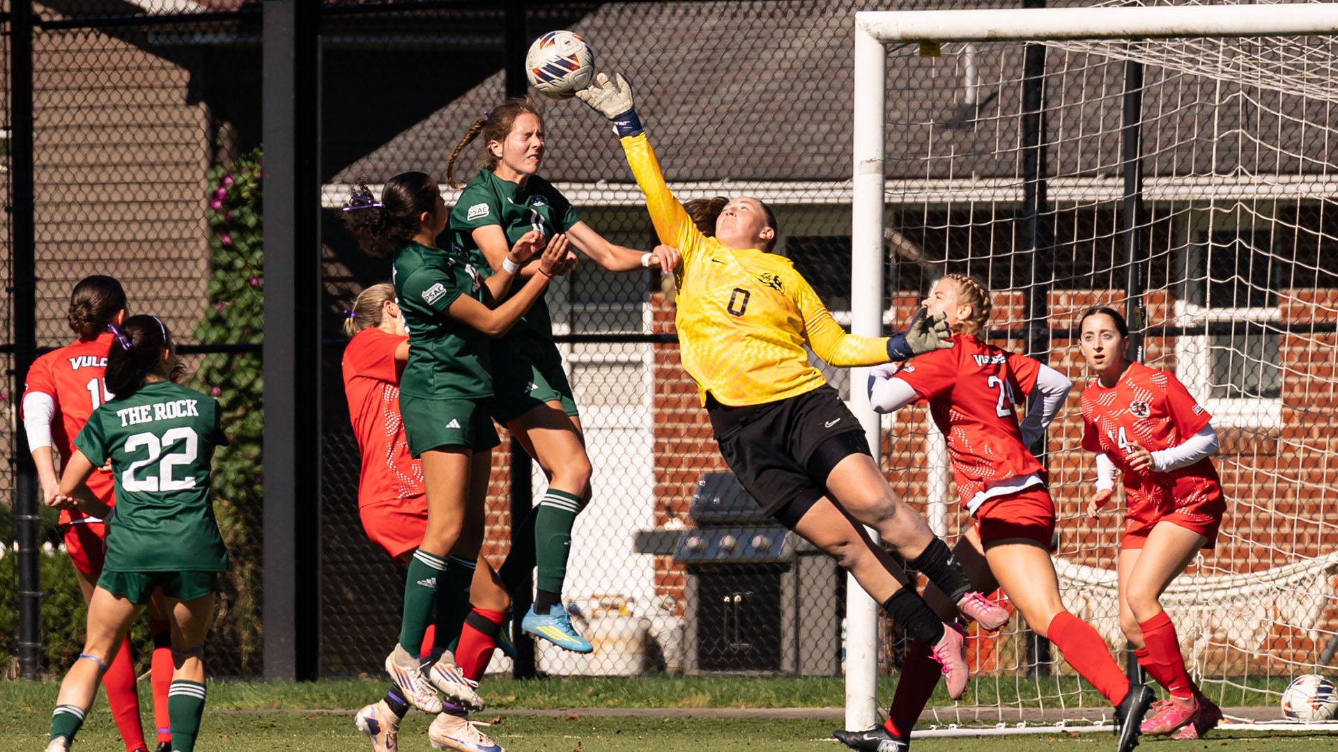 California goalkeeper Kaleigh Rexroad leaps and reaches to deflect a high soccer ball near the goal post.