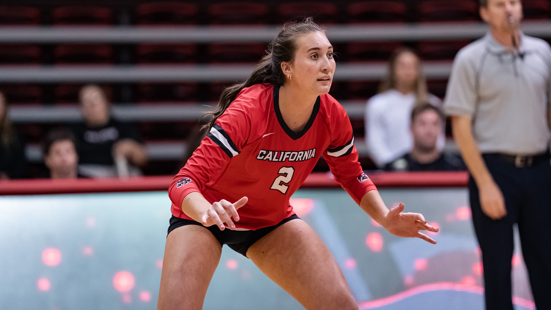 Volleyball player Kasie Meek (#2) stays low in a ready defense position during an indoor match.