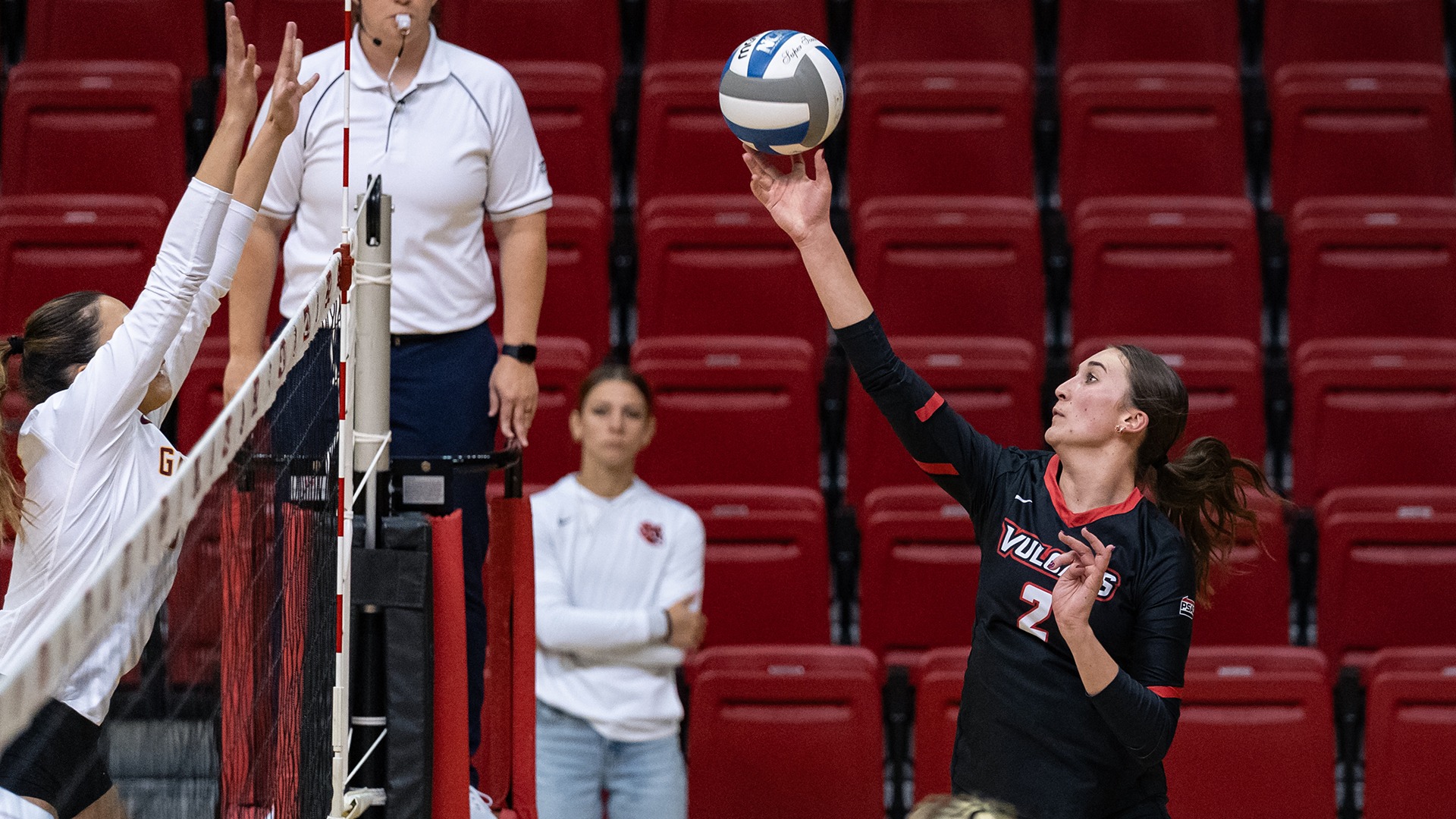 Kasie Meek (No. 2) leaps to attack a volleyball over the net during a home match in the Convocation Center.