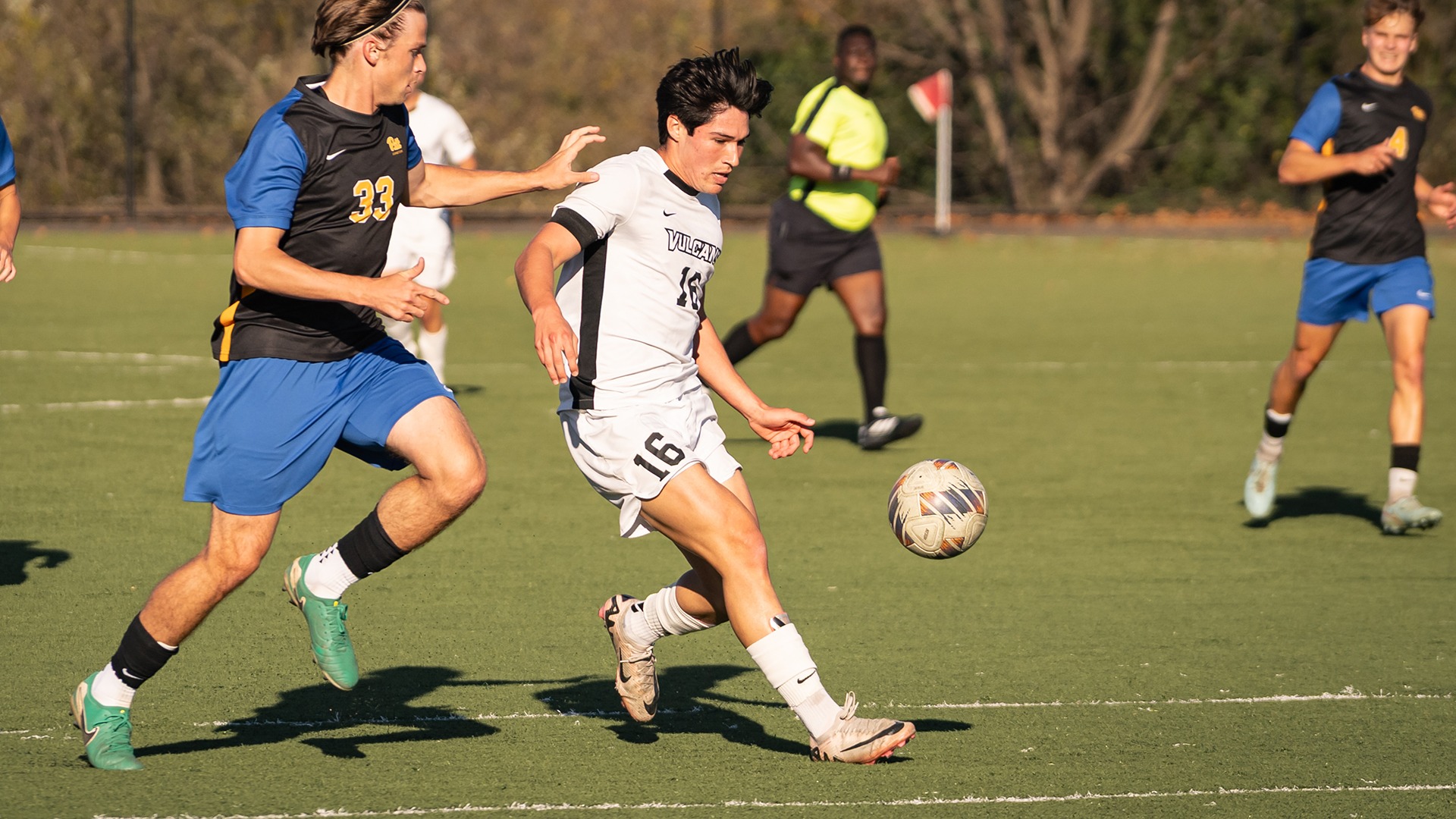 Jaime Marcelo Espinosa (No. 16) controls the ball on the turf while defending against an opponent.