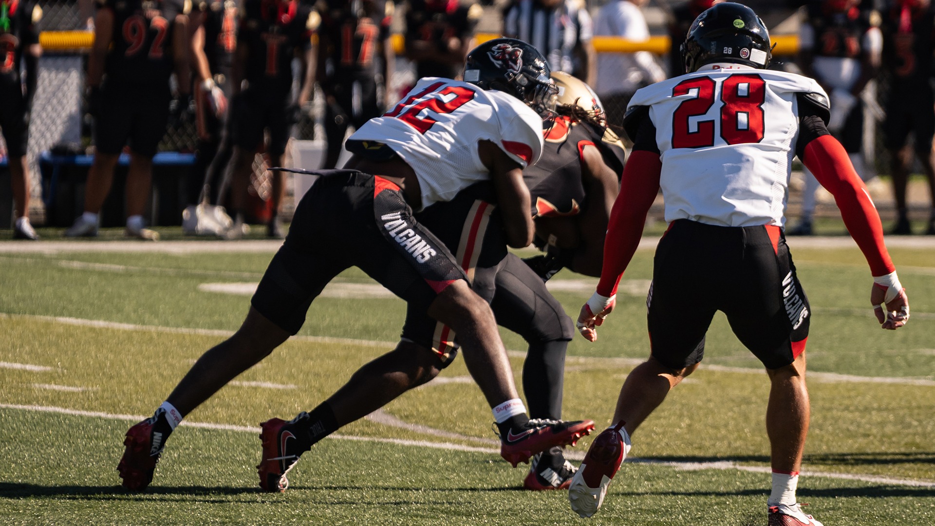 Tajuan Bandy, wearing a white football jersey with red numbers and black pants reading 
