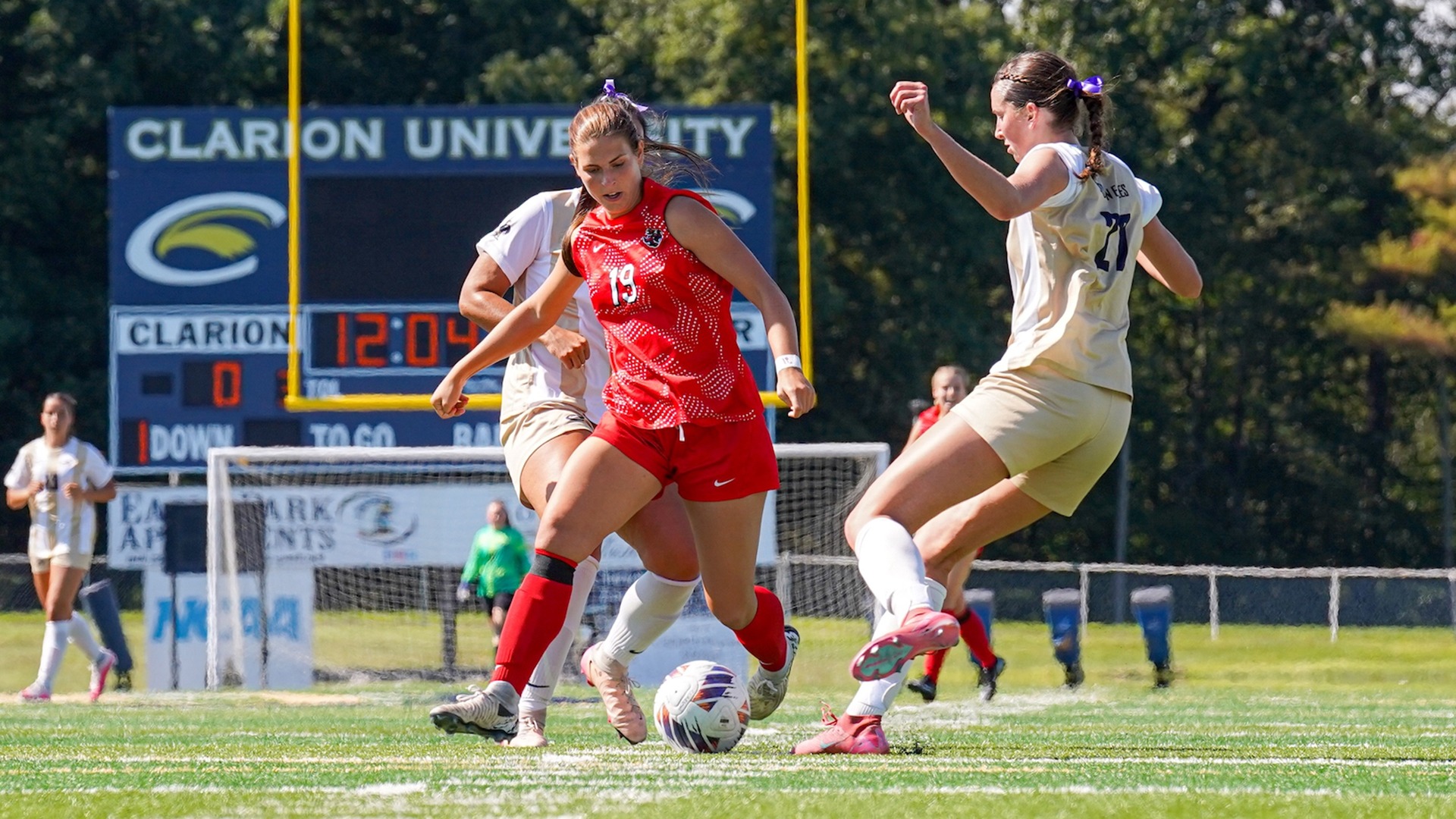 California women's soccer player Alexis Brown (#19) controls the soccer ball on a green turf field during a match at Clarion.