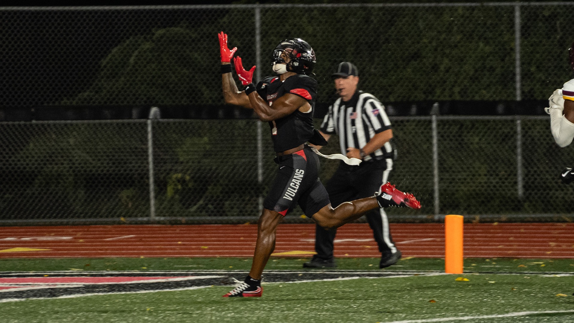 Wide receiver Kenny Lewis IV (#1) reaches up to make a catch during a night football game against Charleston (WV).