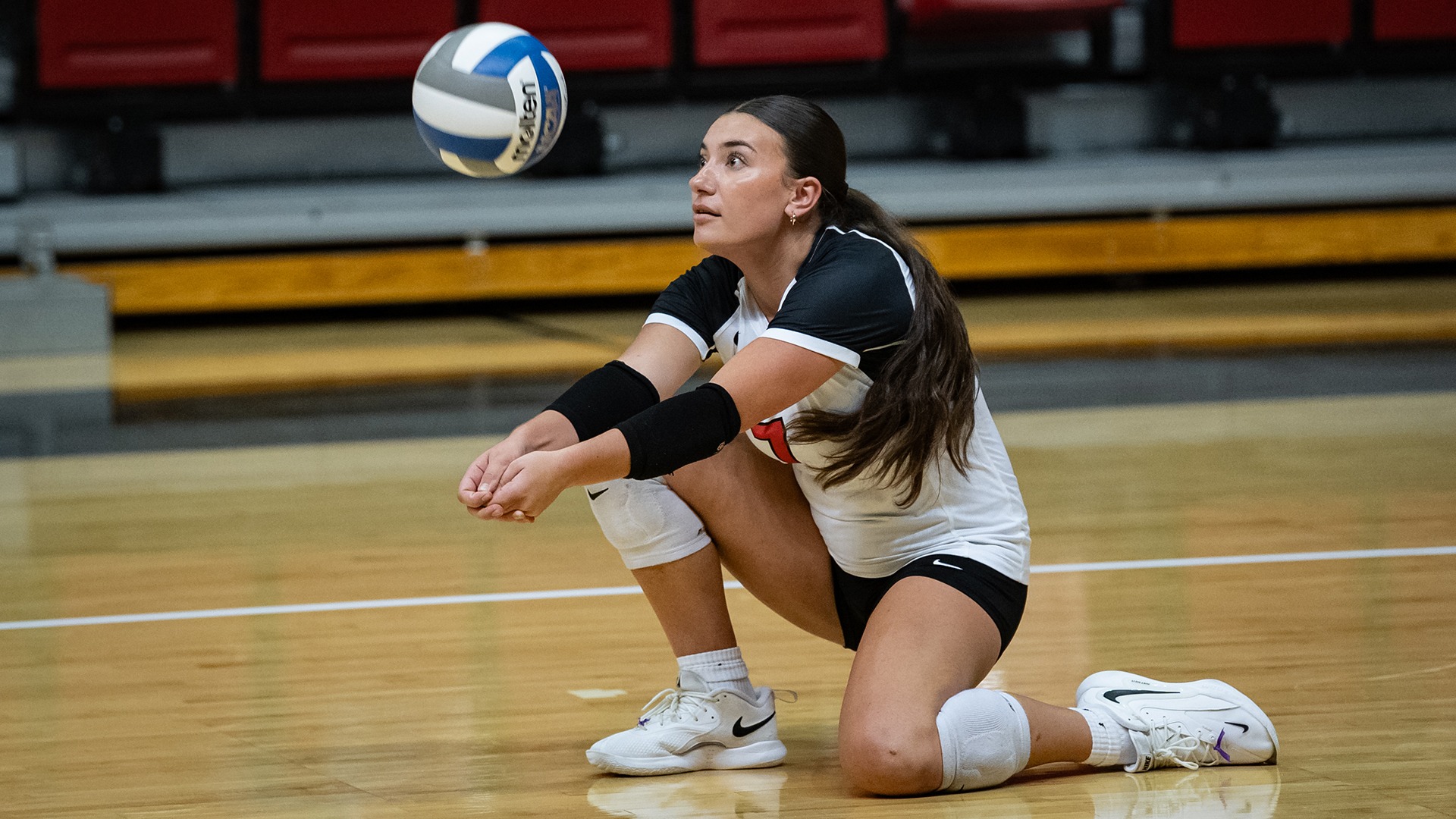 Aubrey Bumblis stays low on the volleyball court, tracking the ball for a pass during a match against West Virginia Wesleyan.
