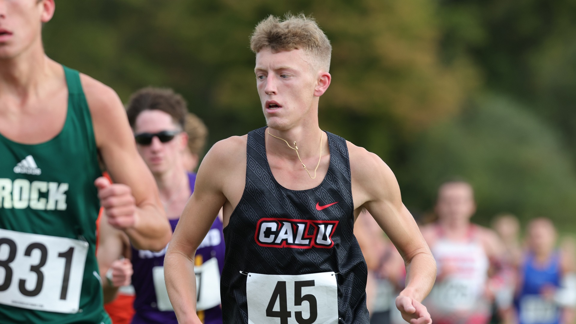 Justin Gross running in a black Cal U tank top with bib number 45 during a cross country race at the 2025 Carnegie Mellon Invitational.
