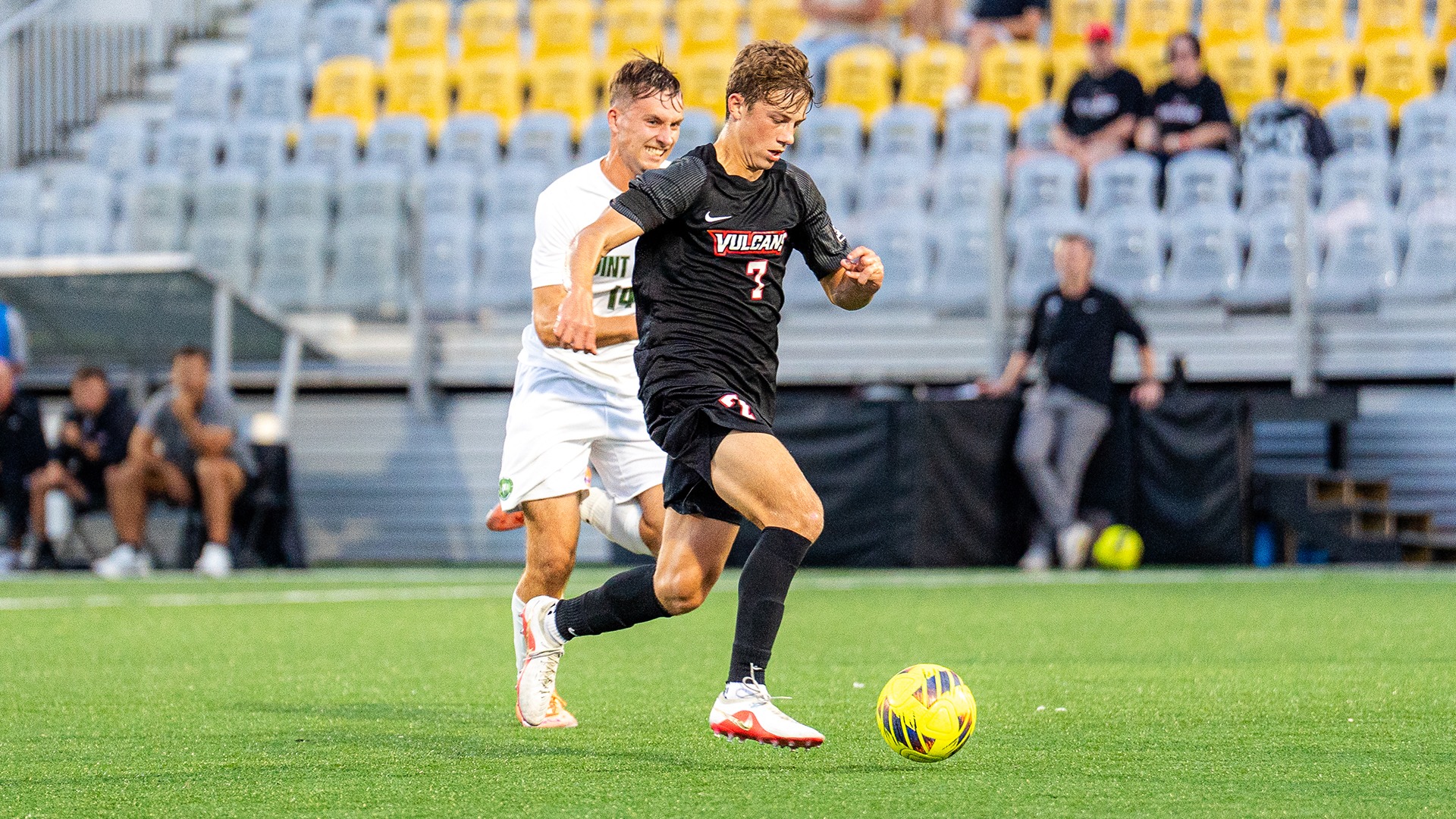 California soccer player Ryan Moessner dribbles a yellow soccer ball down the field during a game against Point Park.