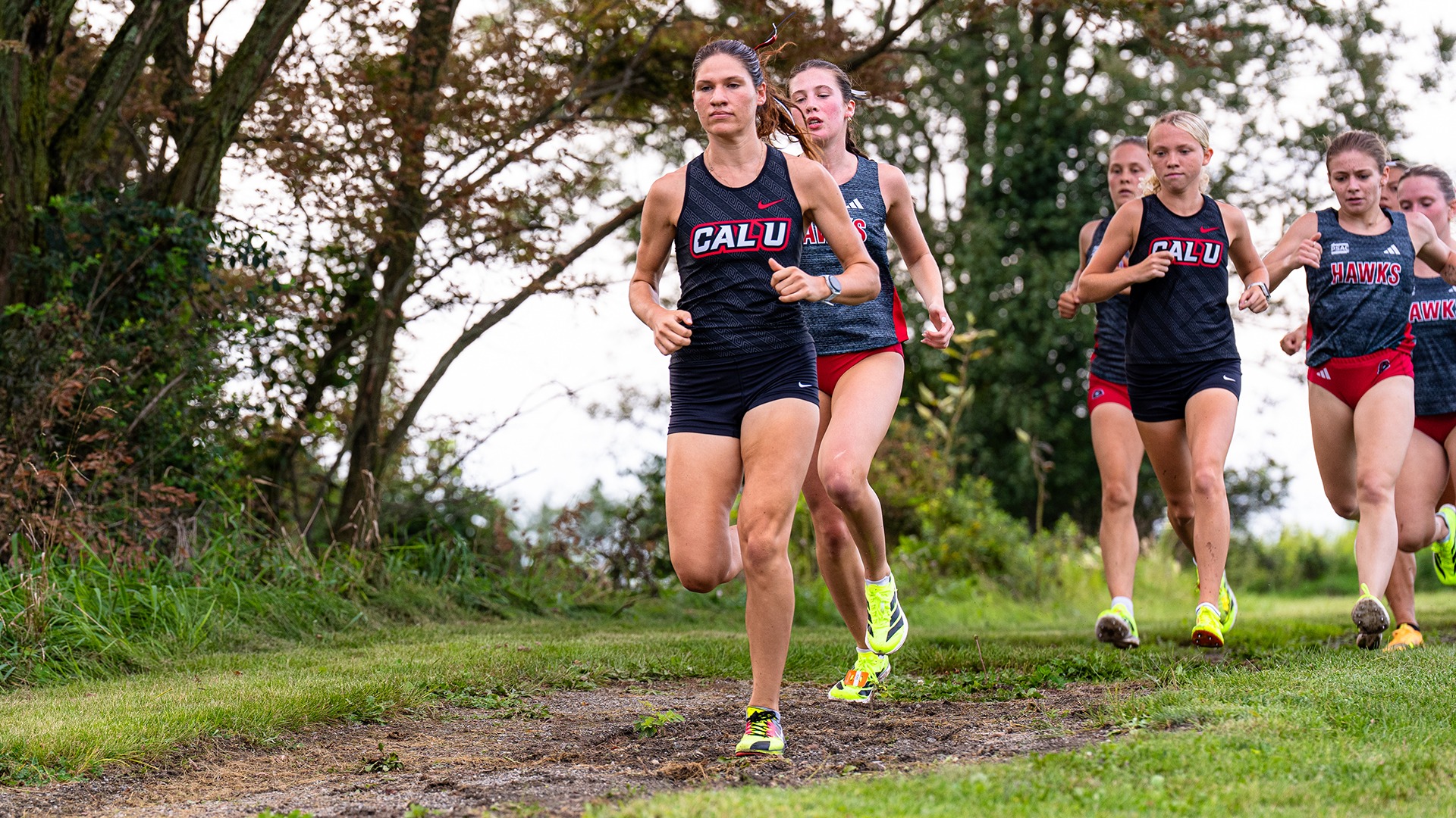 California cross country runner Rosalyn Perozzi leads a pack of competitors along a grassy trail during a dual meet against IUP.