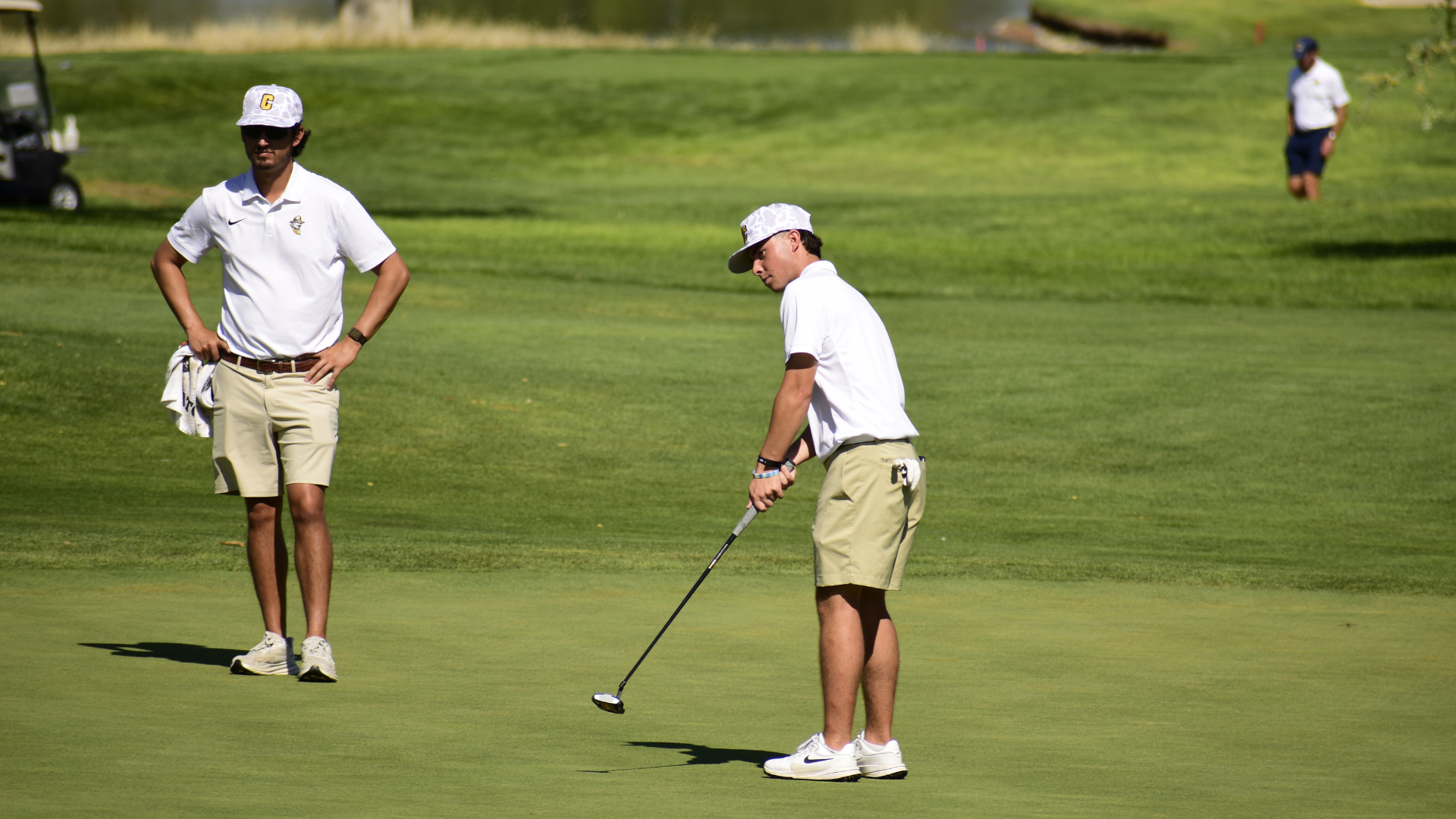 Cameron Golfer attempts putt while coach watches on.