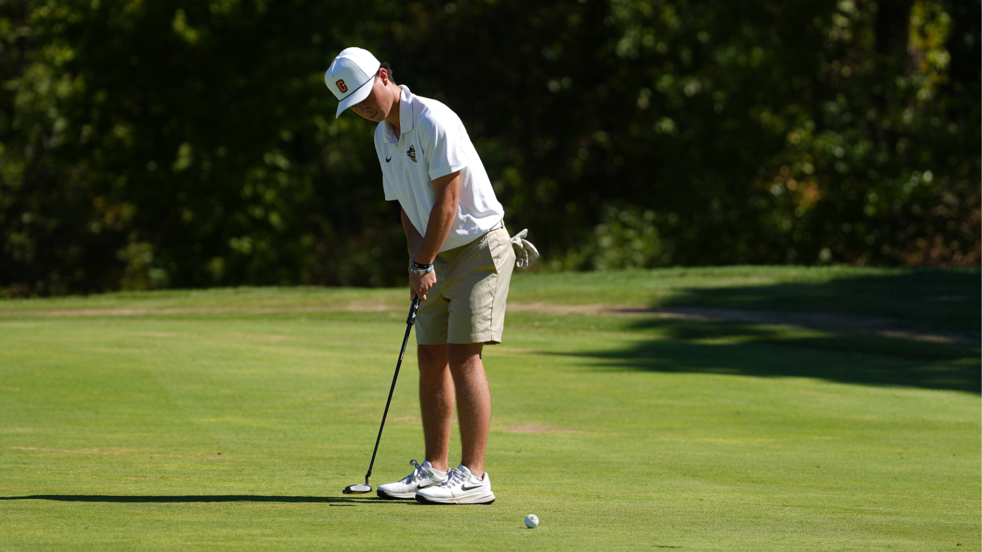 Cameron men’s golfer lines up a putt on the green during tournament play