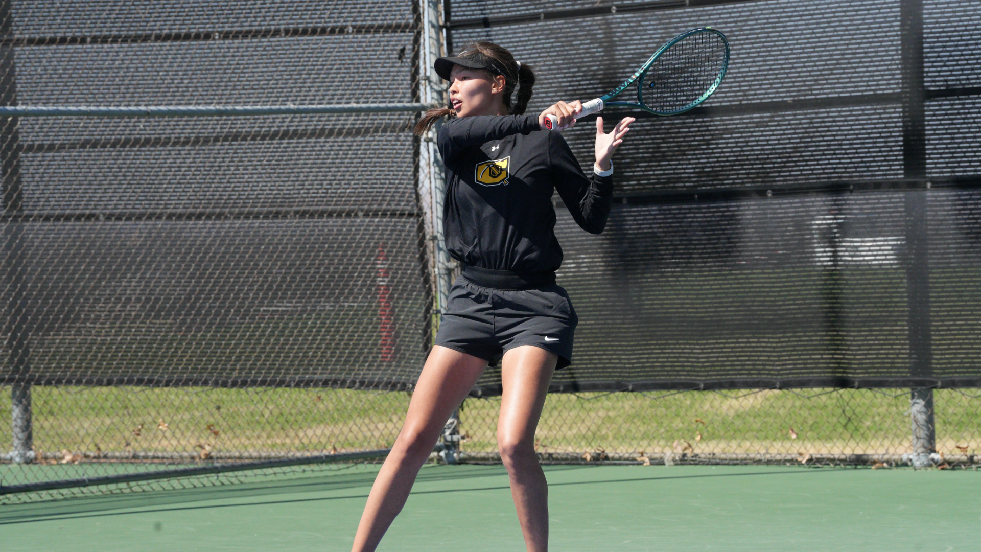 Cameron women's tennis player following through on a forehand swing