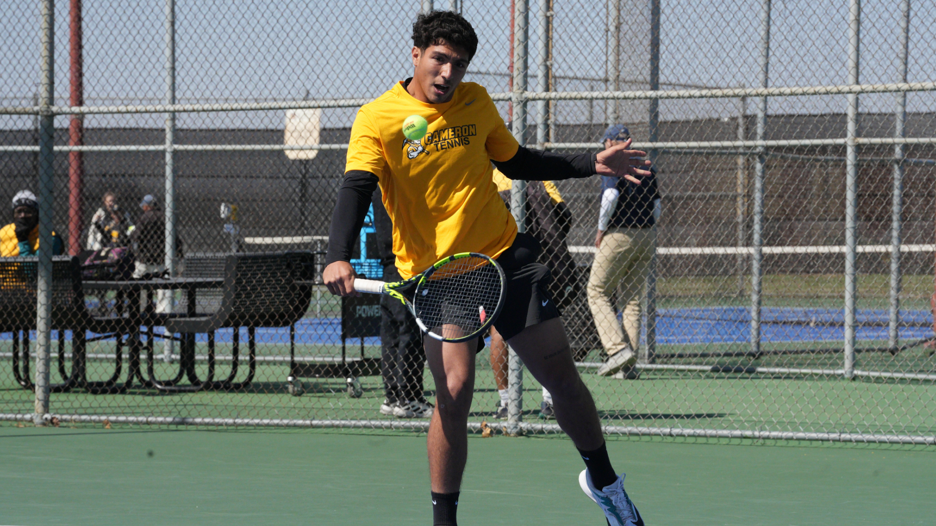 Cameron men's tennis player hitting a backhand