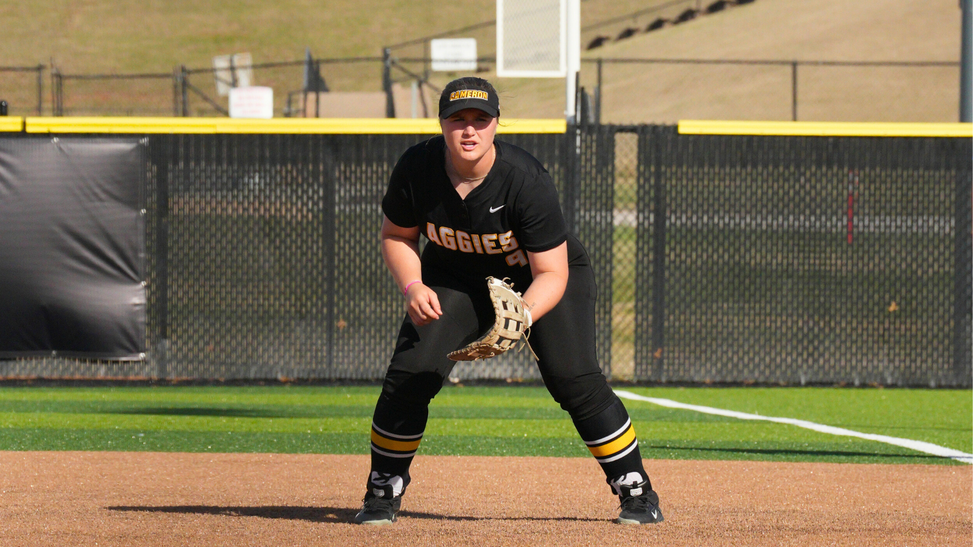 Cameron softball player Madison Boutwell in ready stance at first base